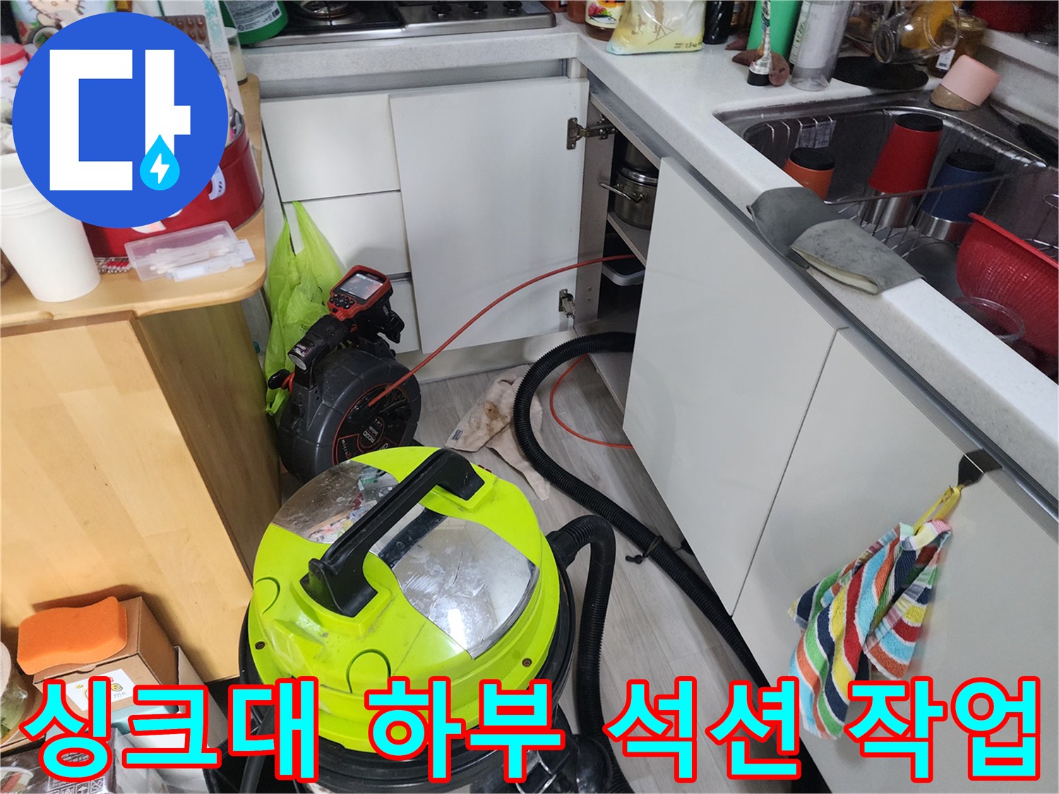 강북구 수유동 주방 싱크대 하부 배관 내부의 이물질을 제거하기 위해 석션기를 사용하는 모습입니다.
