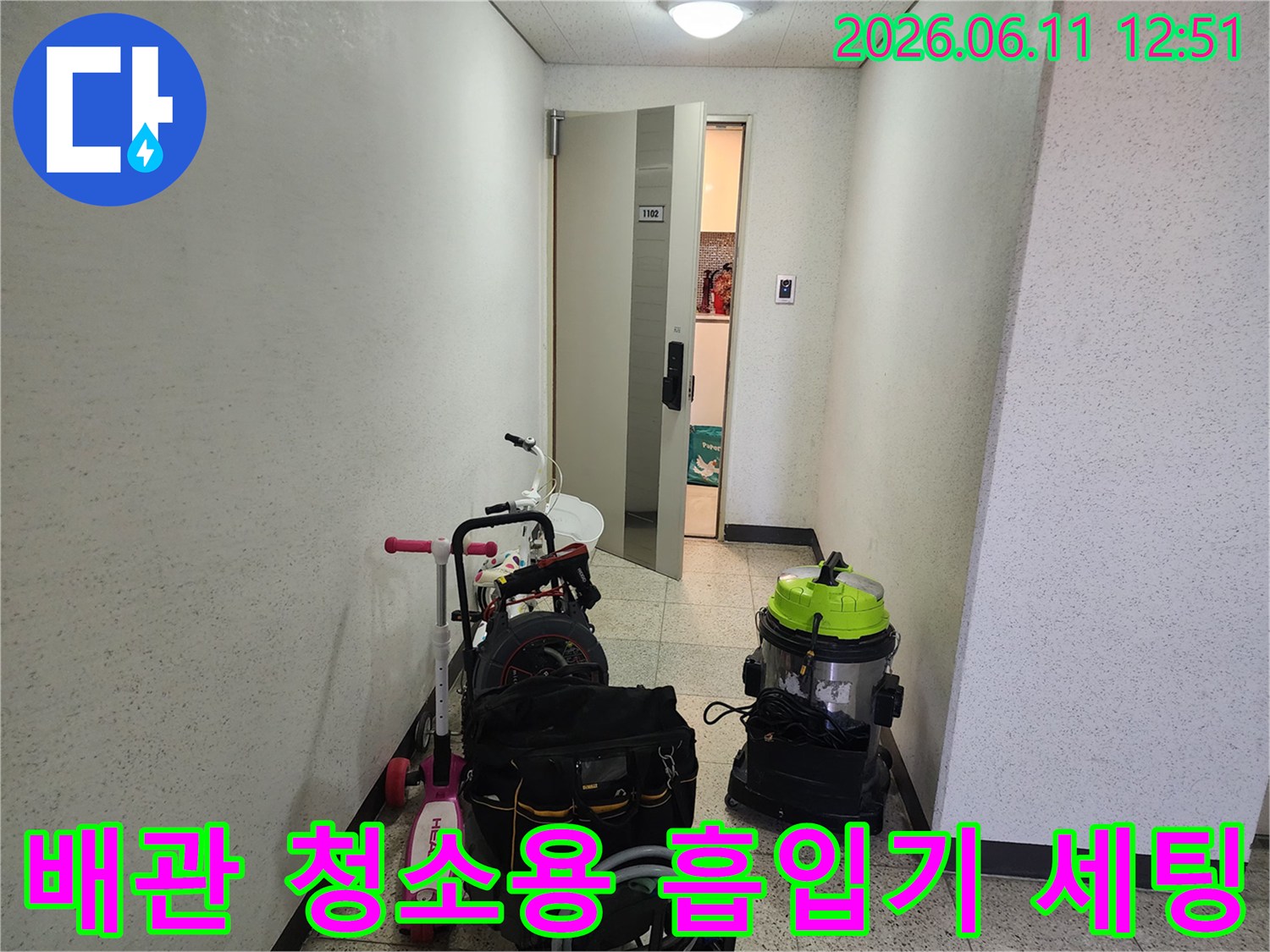 복도에 놓여 있는 배관 청소용 진공 장비와 작업 도구들입니다.