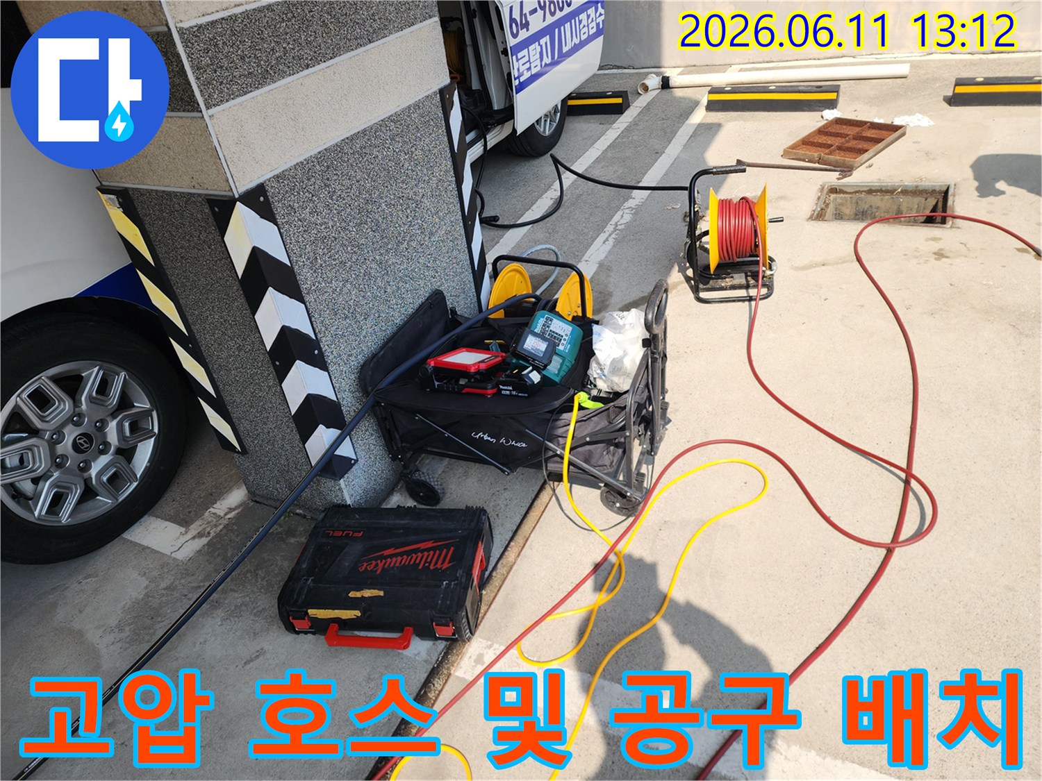 바닥에 연결된 빨간색 고압 호스와 밀워키 공구함 세팅