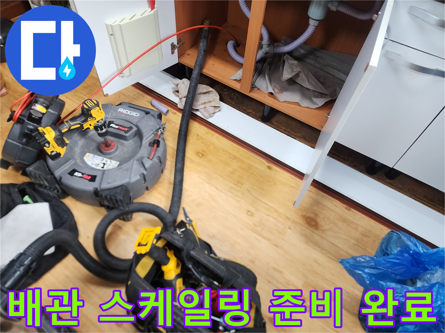 싱크대 하부 배관 청소를 위해 세팅된 리지드 전동 드릴과 작업용 도구들