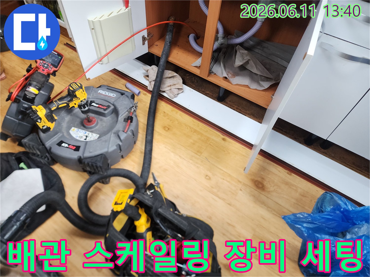 하부장 내부 배관을 청소하기 위해 배치된 리짓 전문 장비와 호스들입니다.
