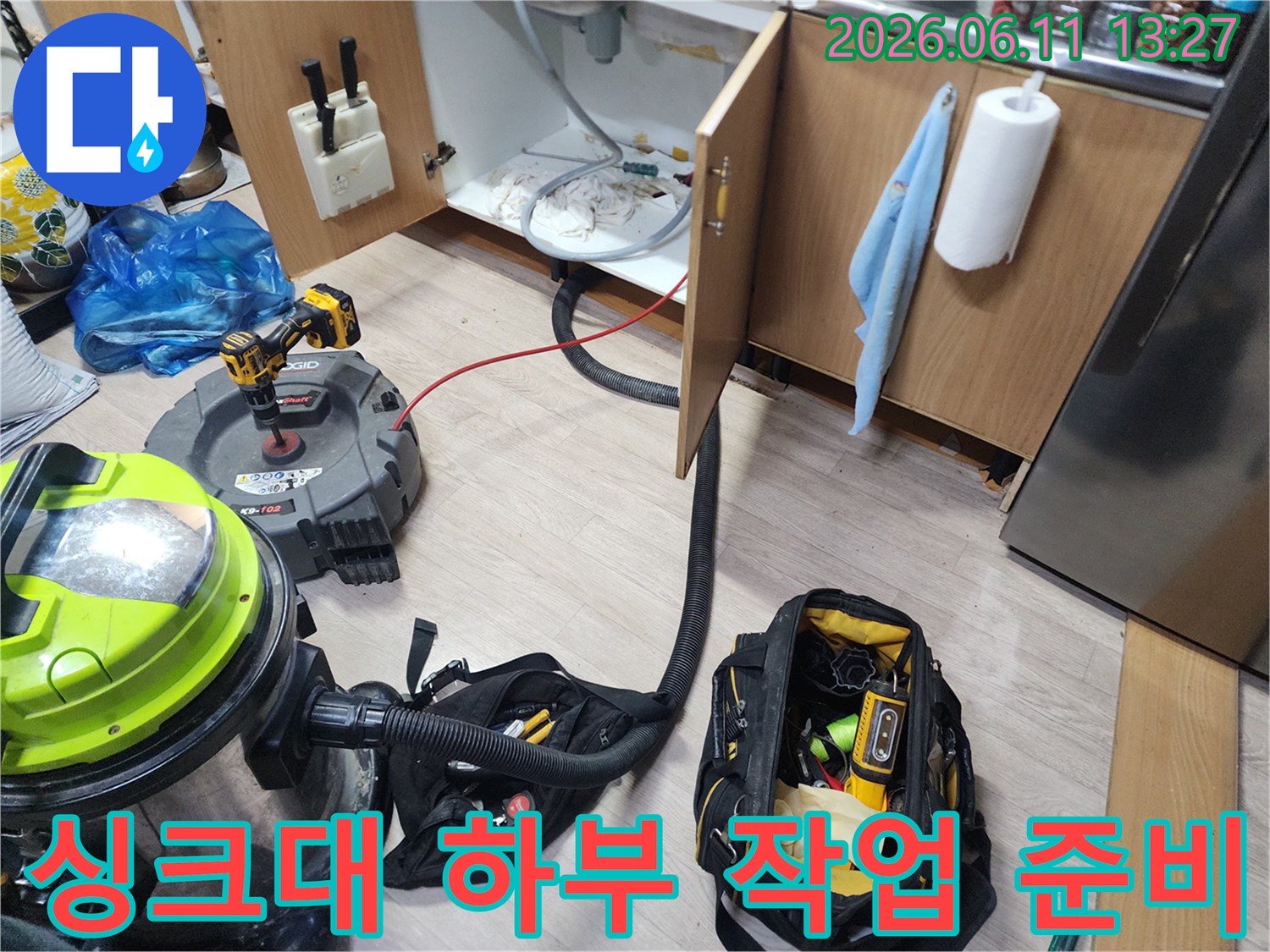 주방 싱크대 아래쪽 배관 작업을 위해 석션 호스와 장비들을 연결한 모습입니다.