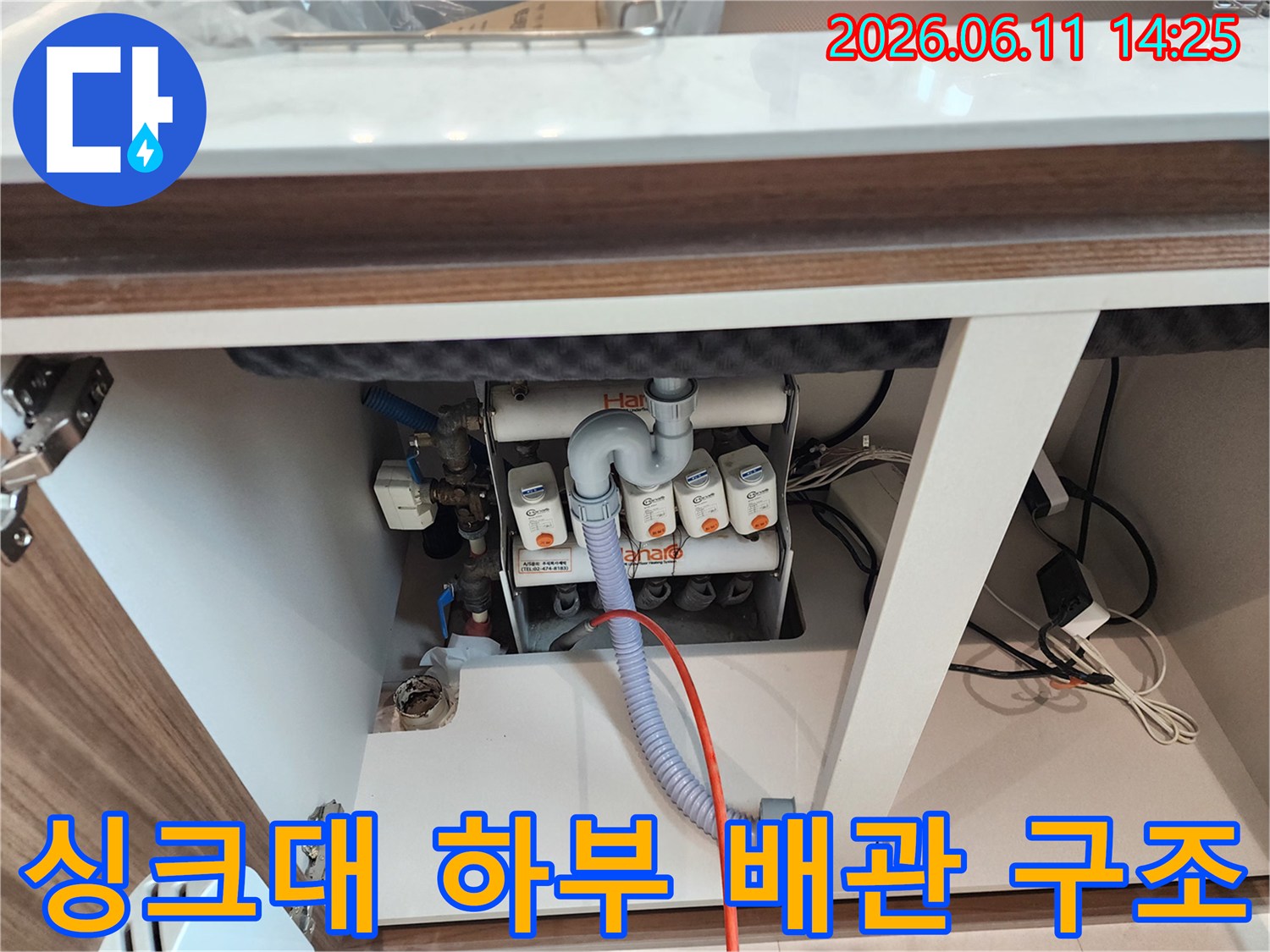구리시 교문동-싱크대 하단에 연결된 복잡한 배수관과 호스 상태를 보여주는 사진입니다.