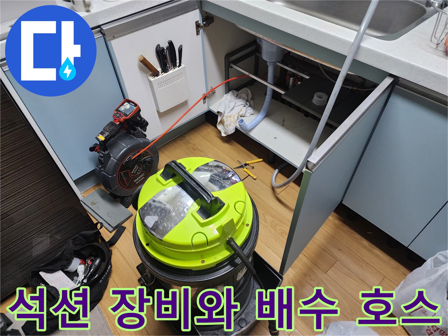 주방 싱크대 밑에서 작동 중인 강력 석션기와 연결된 배수관