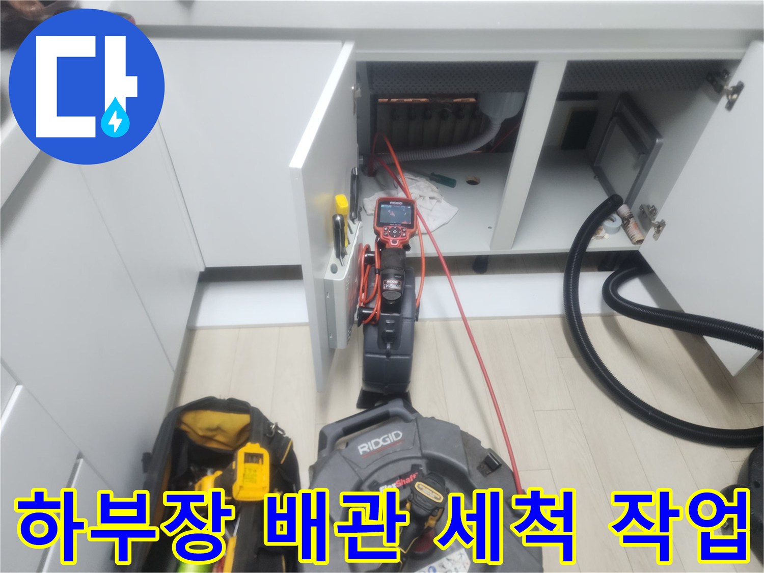 싱크대 아래 공간에서 배관 내부의 이물질을 제거하기 위해 가동 중인 전문 장비