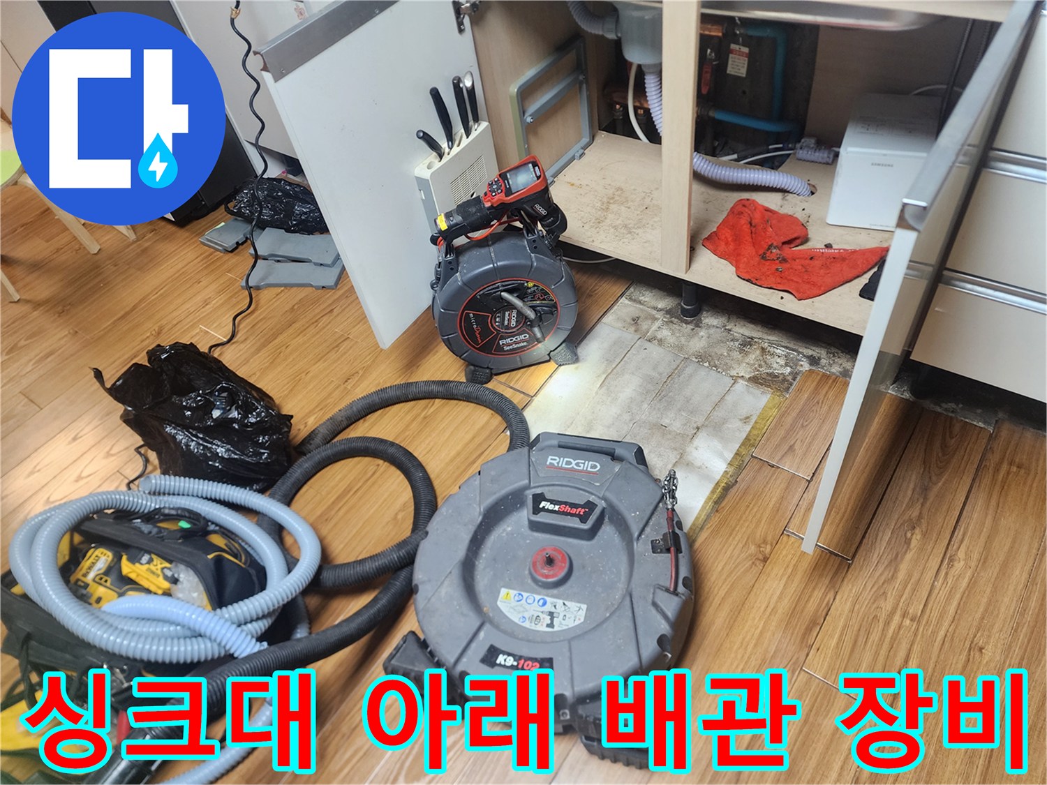 주방 싱크대 하부장 아래 설치된 리지드 스케일링 장비와 석션 호스