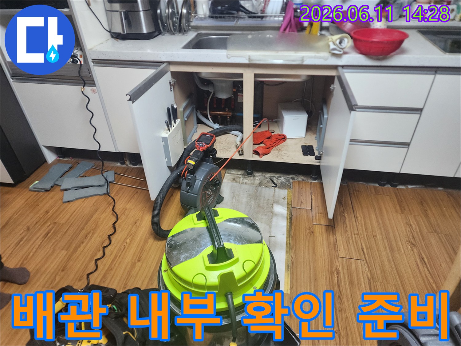 싱크대 하부 배수관 주변의 작업 도구 배치