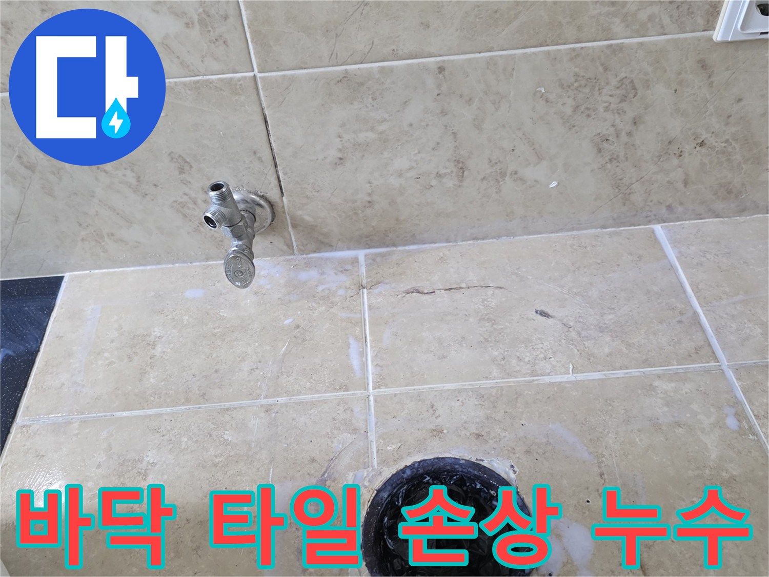 욕실 바닥 타일에 생긴 균열과-그 주변으로 물이 스며든 흔적-그리고 수도꼭지 및 배수구의 모습을 담은 사진입니다