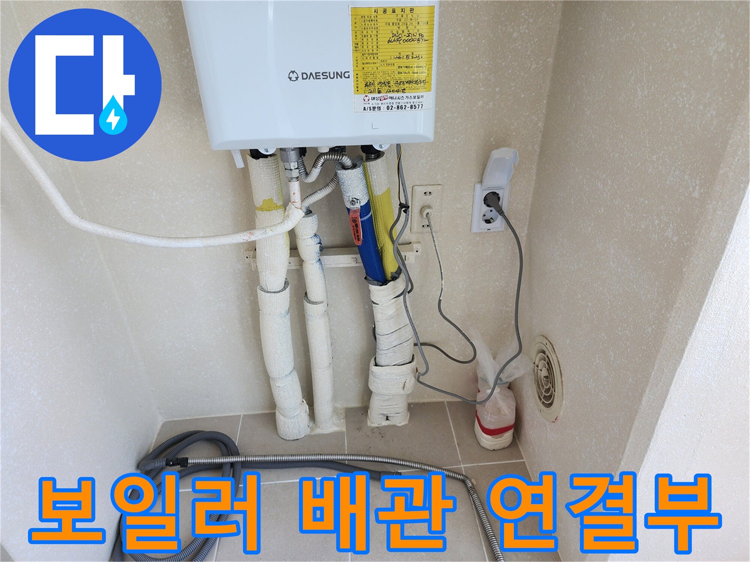 흰색 보온재가 씌워진 보일러 하단 급수 및 온수 배관