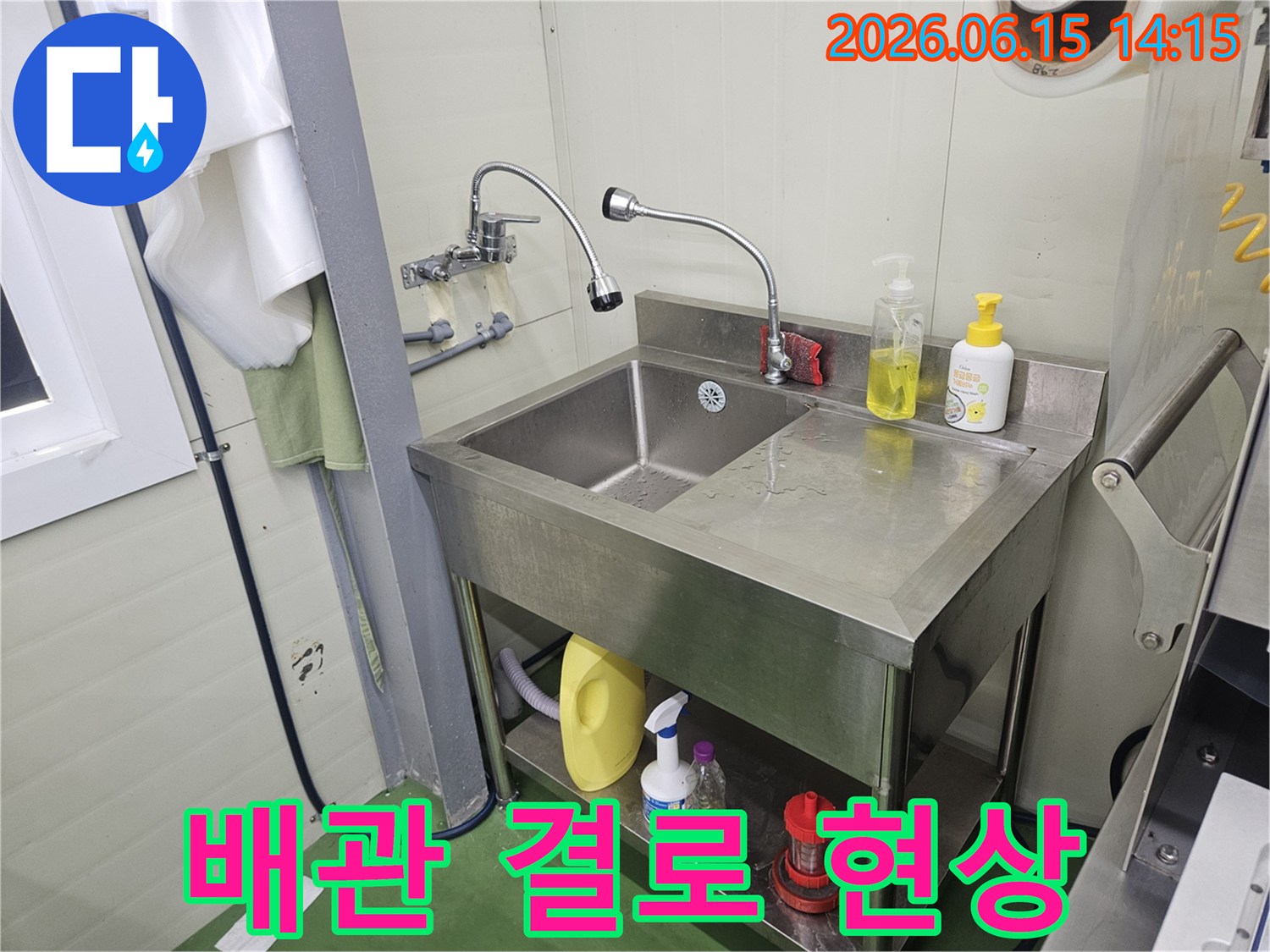 스테인리스-싱크대-아래-하부-배관에-맺힌-결로-현상을-점검하는-누수-전문가의-모습