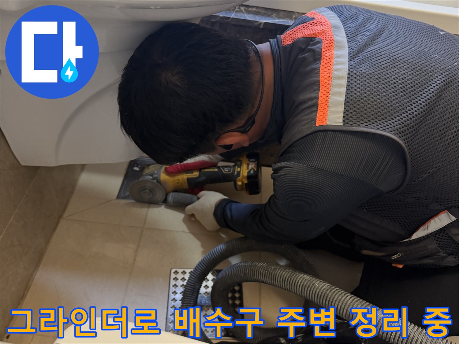 작업자가 그라인더를 사용하여-배수구 주변의 노후 부위를 제거하고 있습니다.