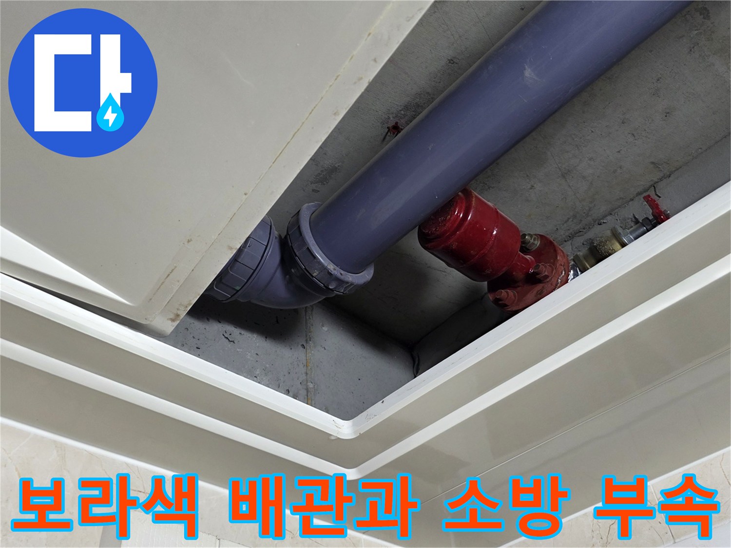 천장 점검구 내부의 하수관 및 붉은색 소방 설비 상세