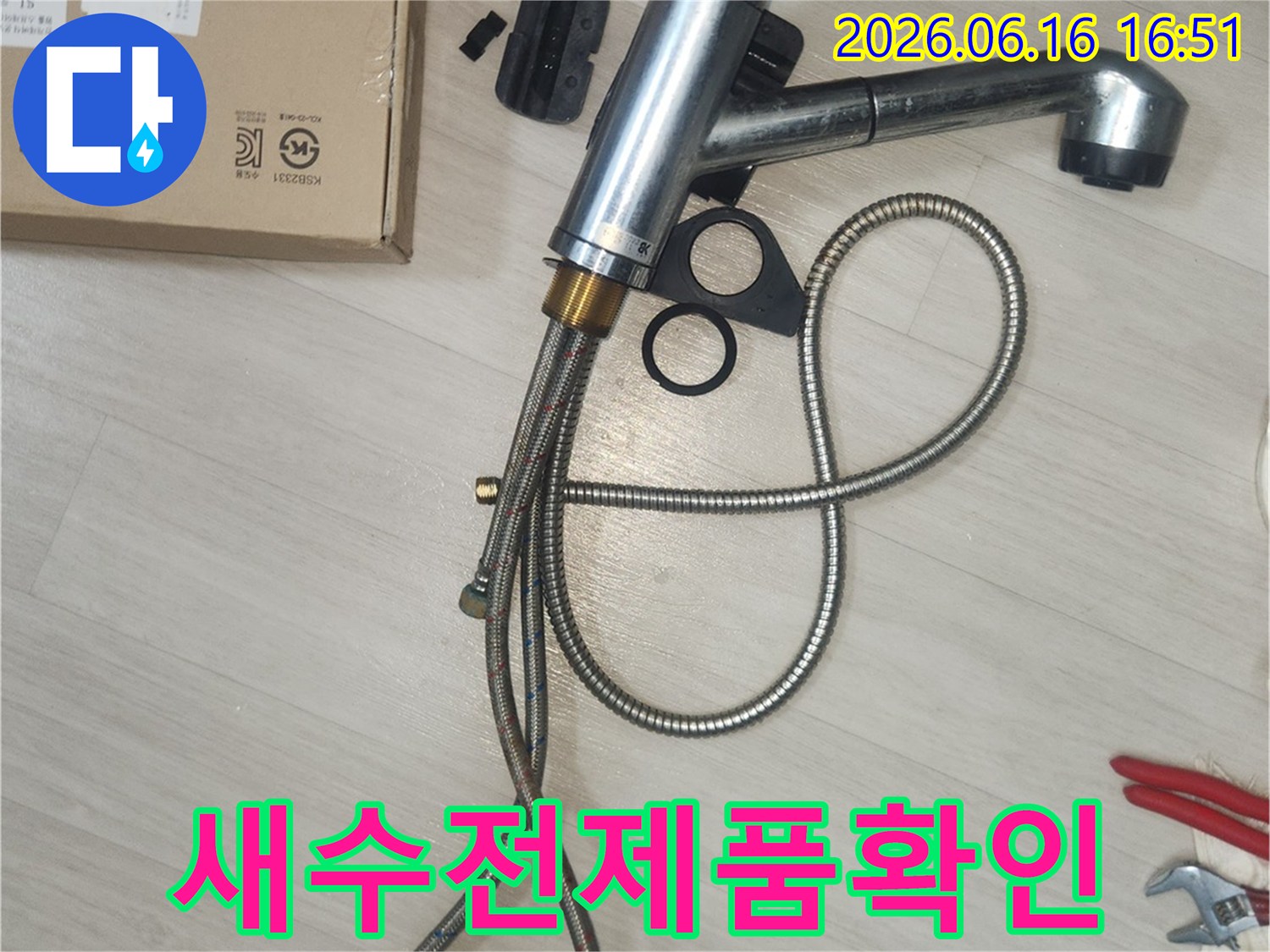 새 싱크대 수전 설치를 위해-제품 박스 옆에 놓인-새 수전의 모습을 보여줍니다