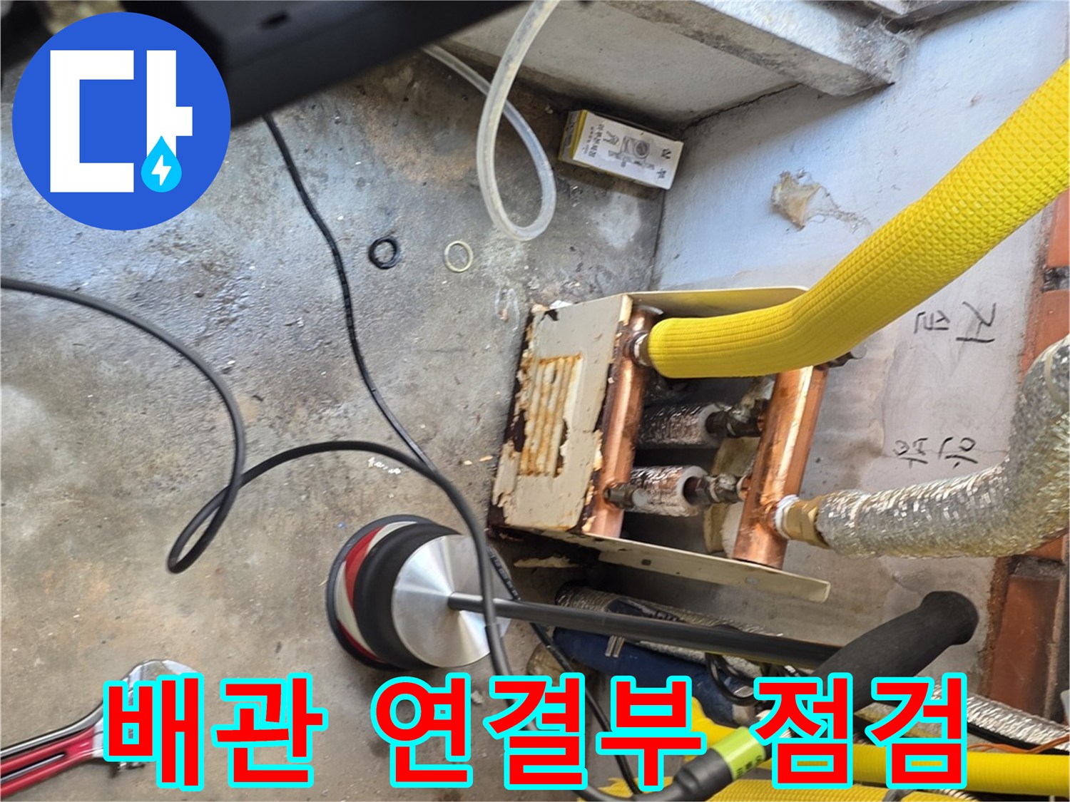 누수 지점을 찾기 위해-배관 연결 부위를 정밀하게 관찰하는 모습