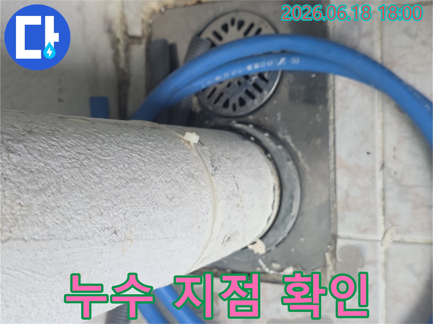 바닥 배수구와-수직 배관의-접합부에서-발견된-미세한-누수 지점을-확대하여-보여줍니다.