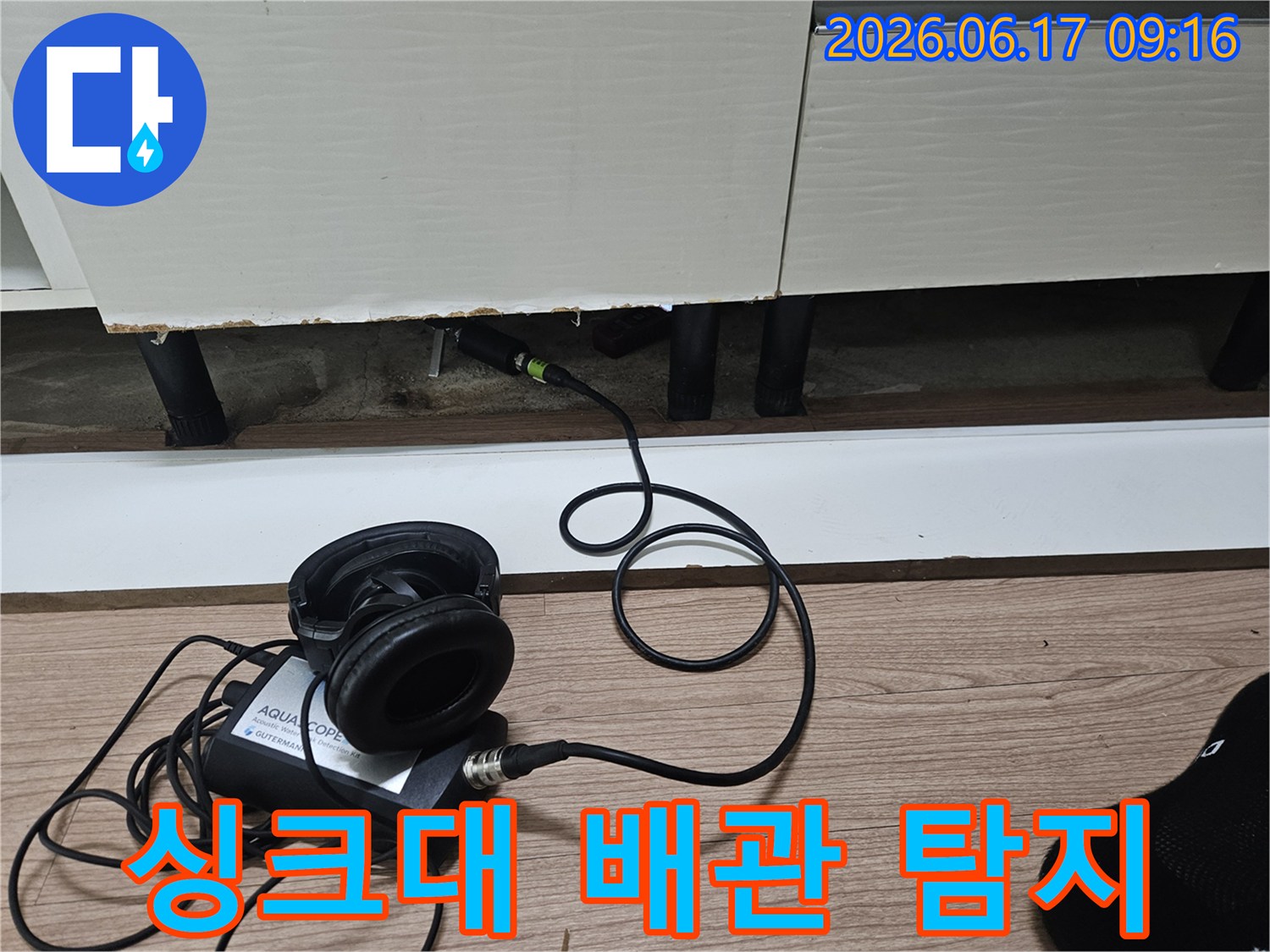 누수 탐지 장비가-싱크대 하부 좁은 공간에 삽입되어-배관 누수음을 감지하는 모습