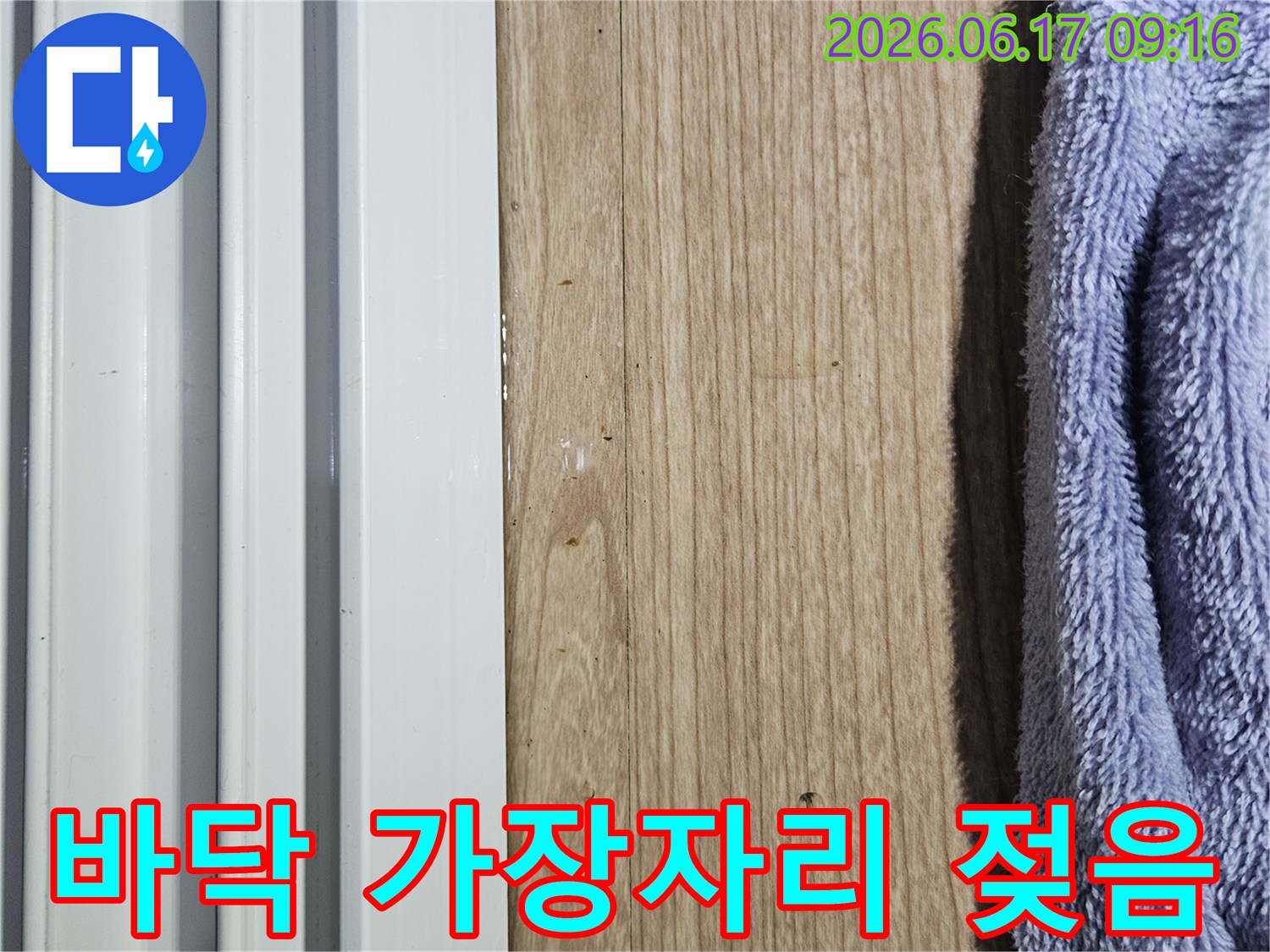 바닥 가장자리에 물기가 스며들어 젖어 있는 상태를 보여주는 누수 현장 사진
