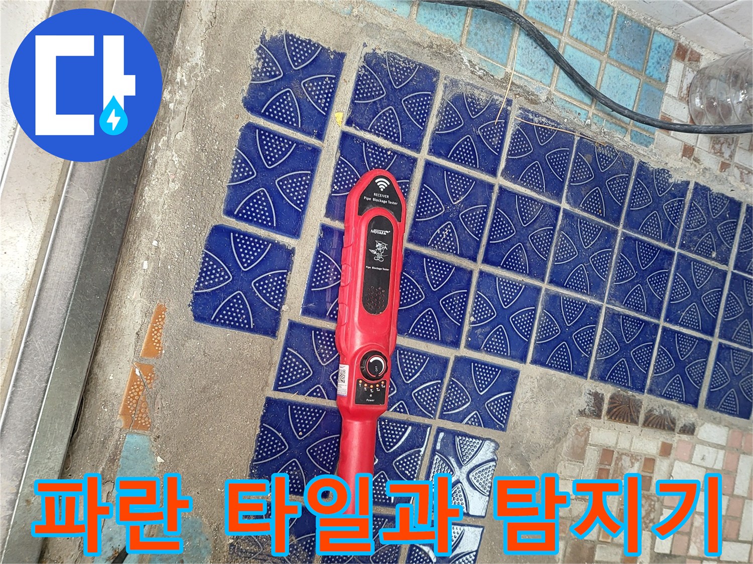 푸른색 패턴 타일 위에 놓인 붉은색 가스 탐지 장비