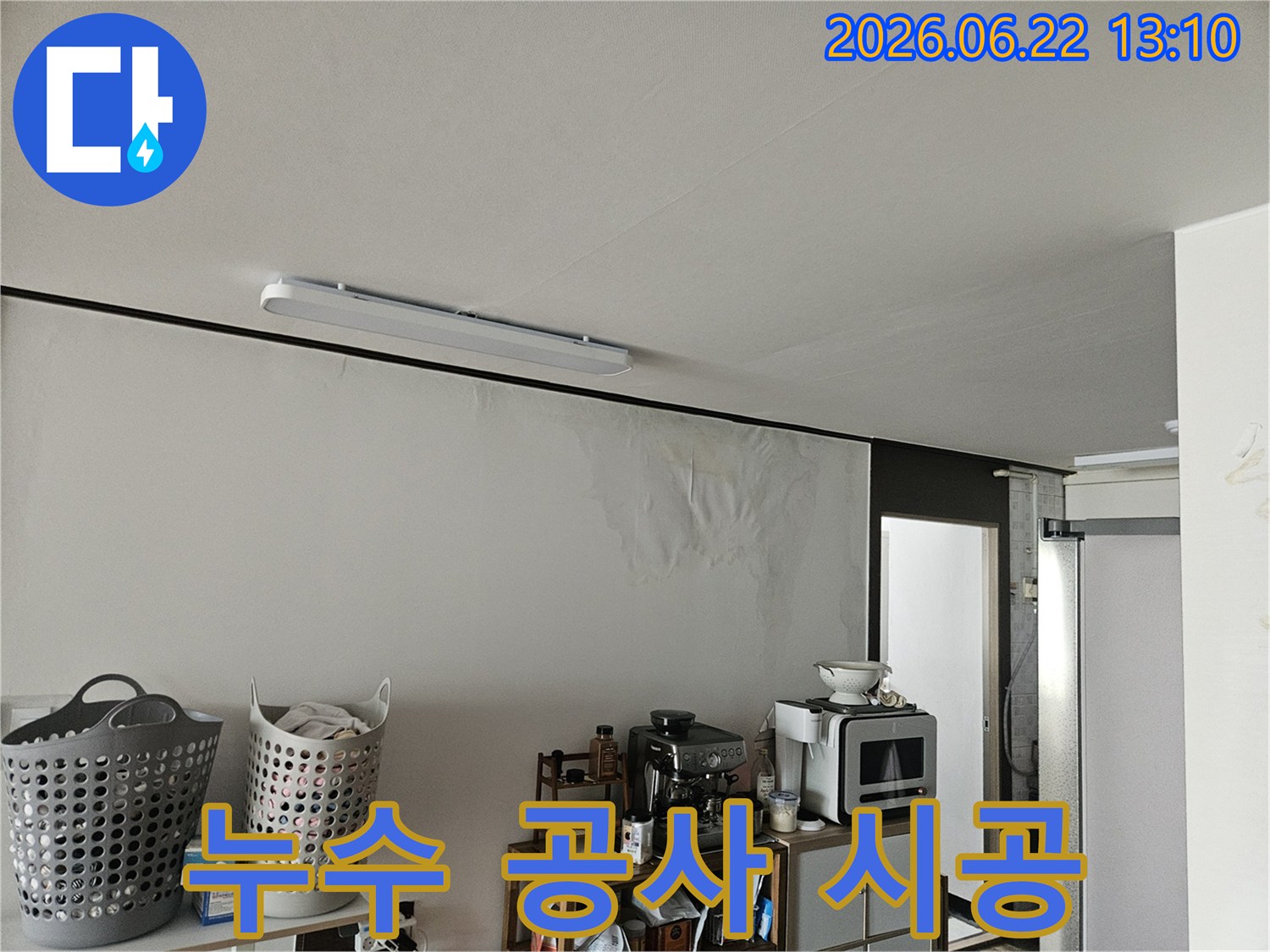 물에 젖어 얼룩지고 손상된 벽면과-그 위로 보이는 천장의 모습에서 누수의 심각성을 짐작할 수 있는 사진입니다.