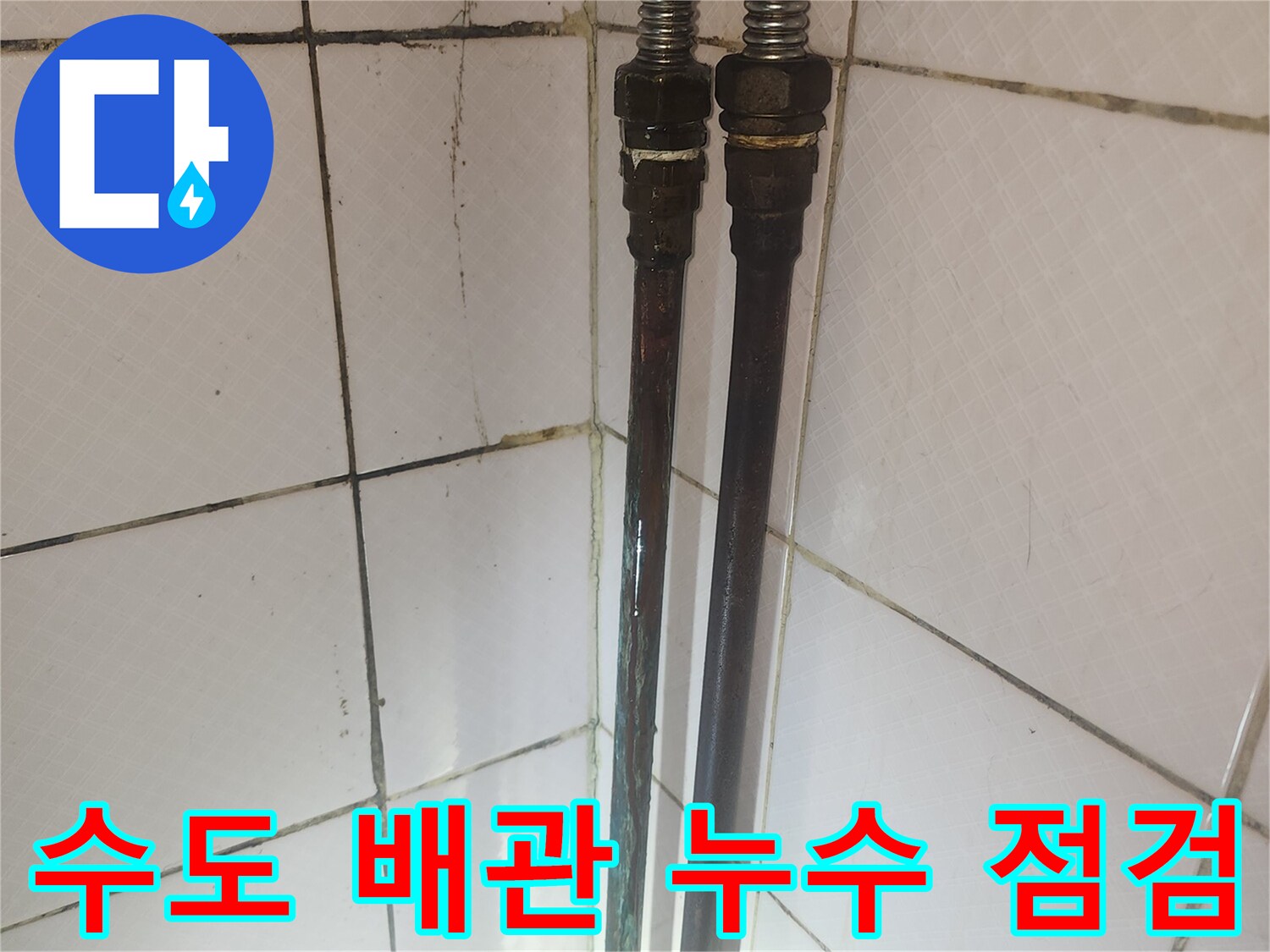 오래된 수도 배관의 연결 부위와 주변 타일의 상태를 보여주며-누수 점검 과정을 나타냅니다