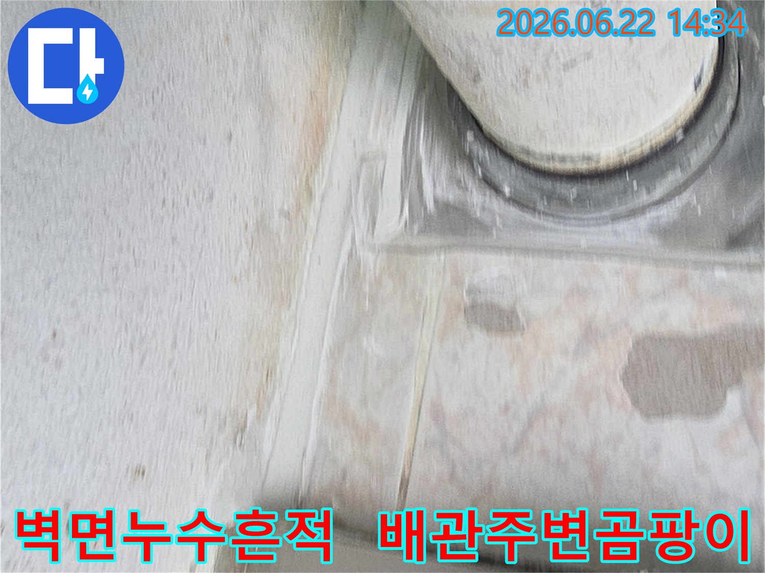 이 이미지는-아파트 벽면 배관 주변에-발생한 누수 흔적과-곰팡이를 보여줍니다