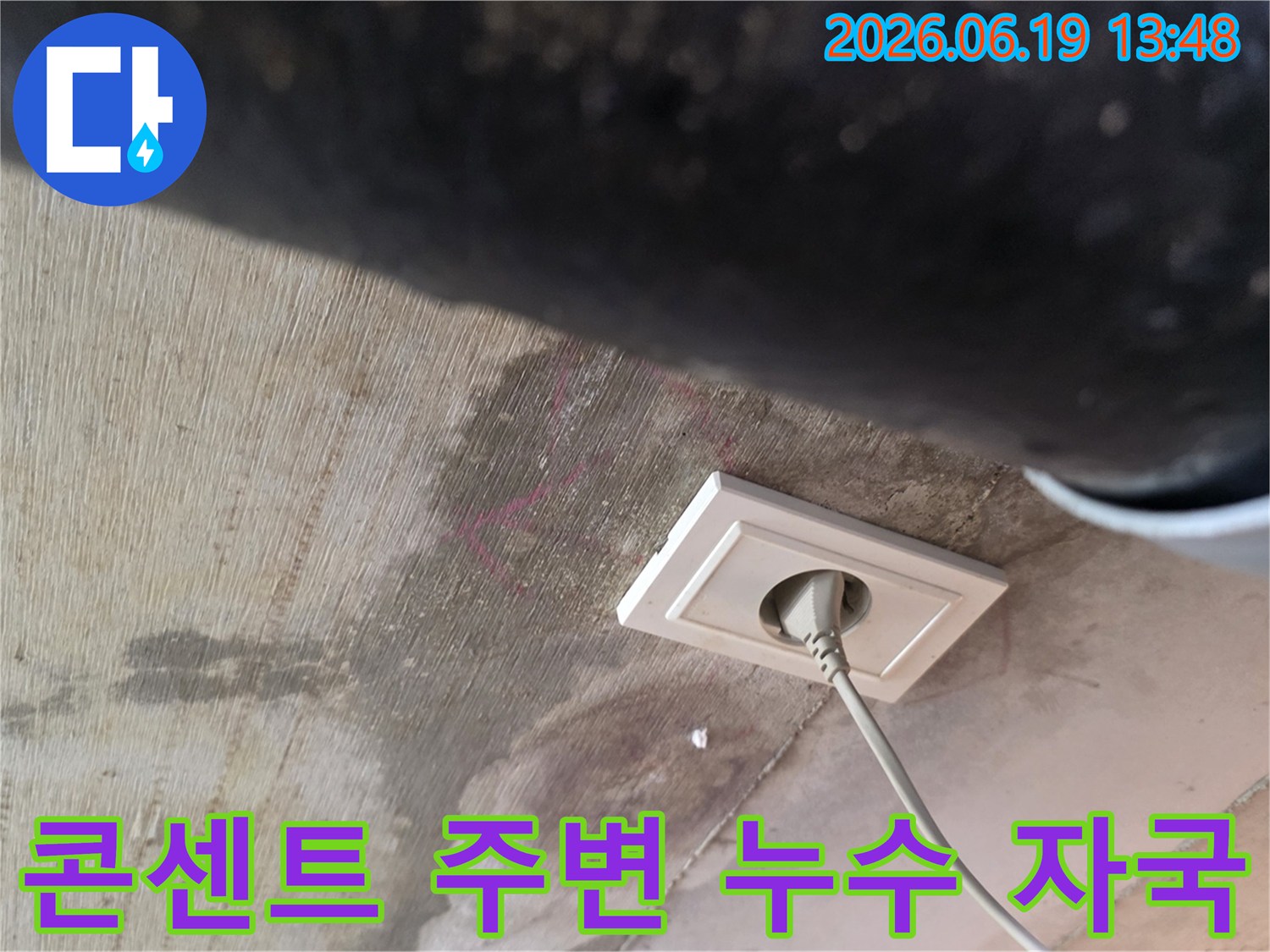 천장 콘센트 주변에 물이 새어 얼룩진 모습으로-누수 피해의 심각성을 보여주는 현장 사진입니다