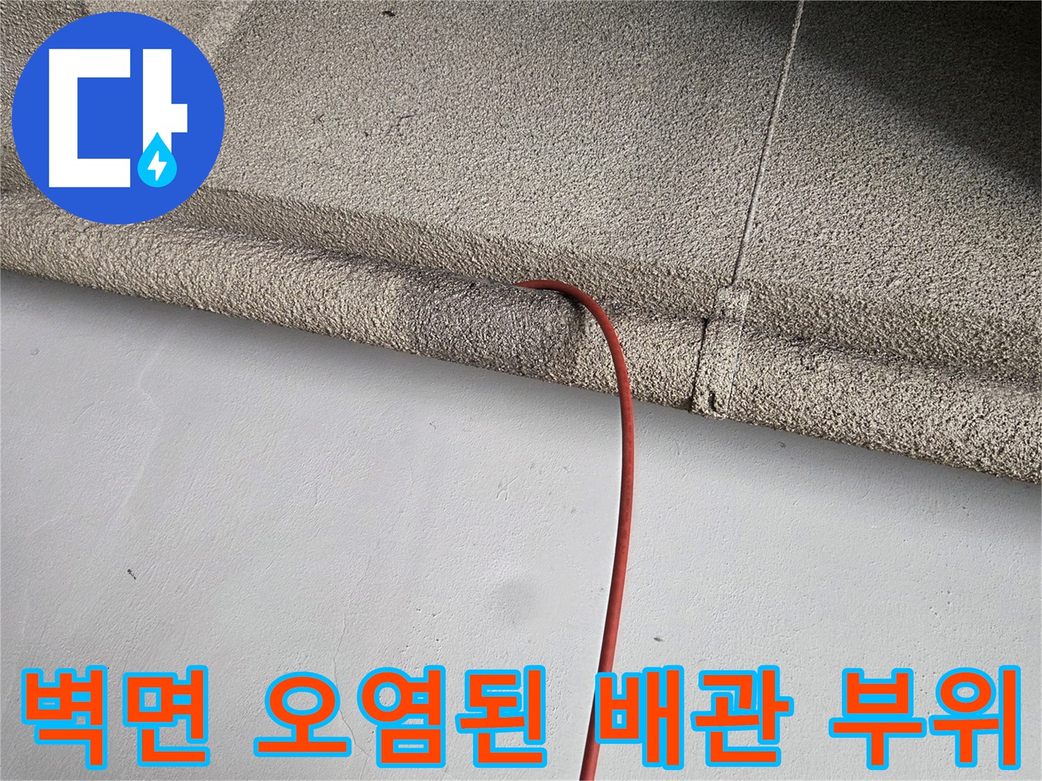 하수 역류 흔적이 남은 거친 질감의 벽면과 배관 연결부