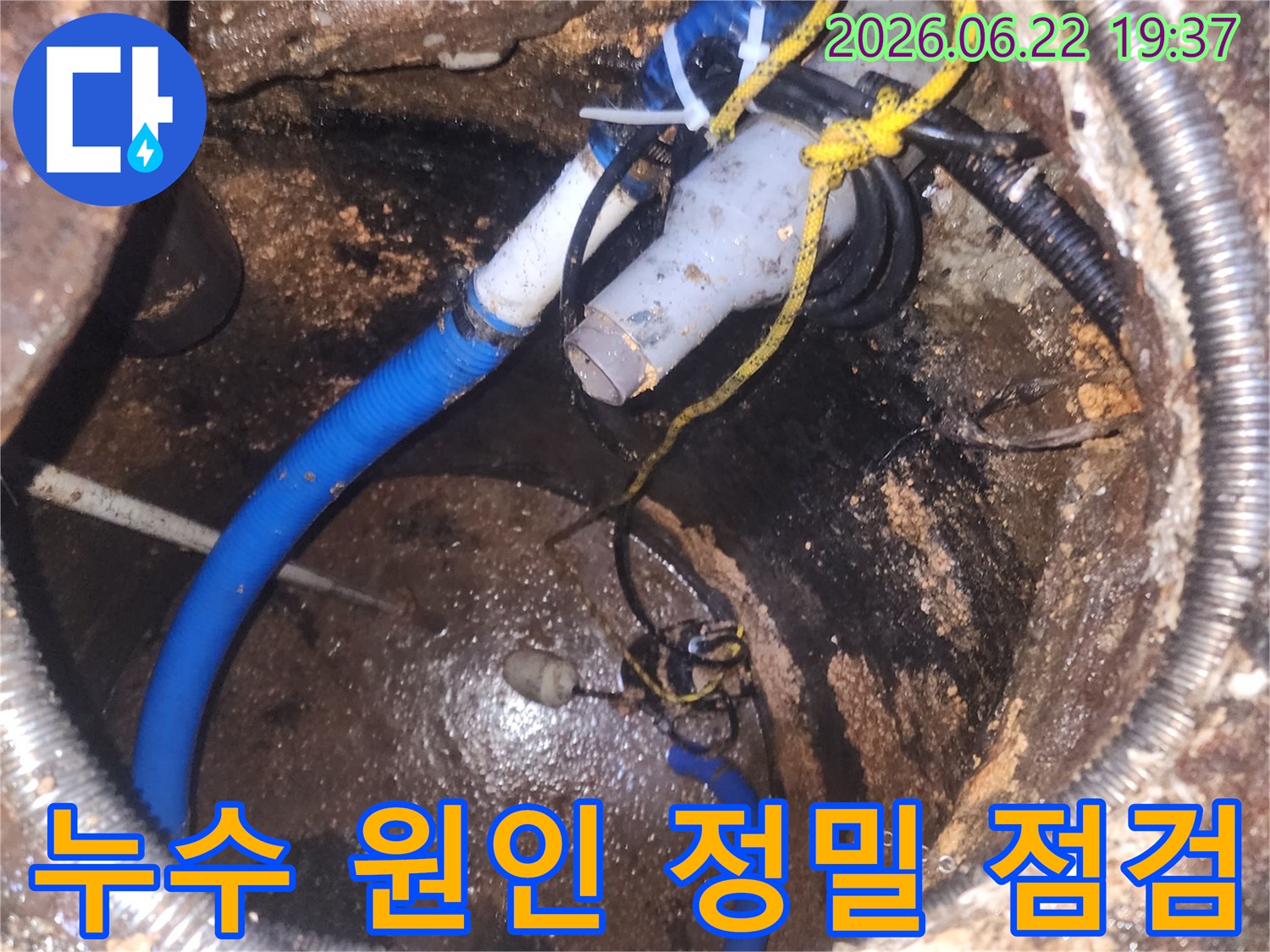 어둡고-협소한-공간에서-다양한-배관과-전선이-얽힌-누수-지점을-확인하는-장면입니다