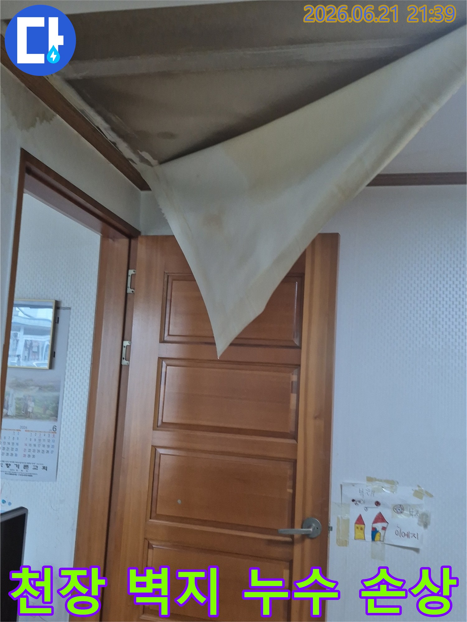 천장 벽지가 물에 젖어 심하게 처지고-부분적으로 찢어진 모습이 보이는 사진