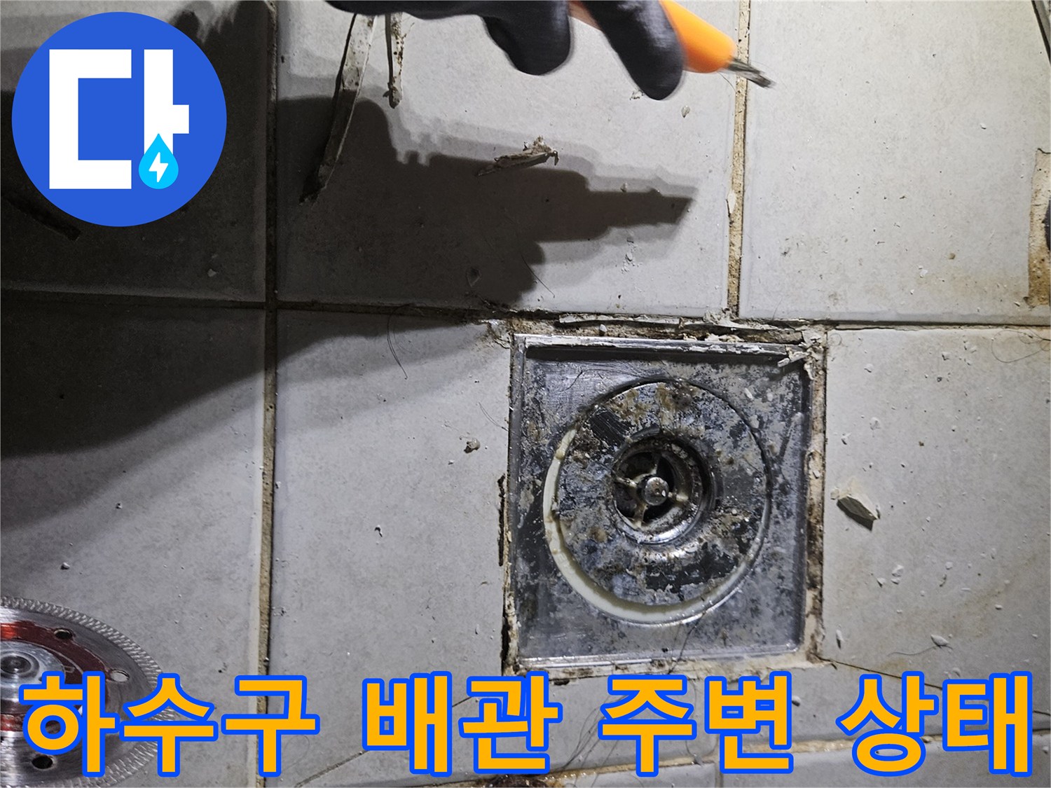 변기 제거 후 드러난 하수구 입구와 오염된 타일 틈새