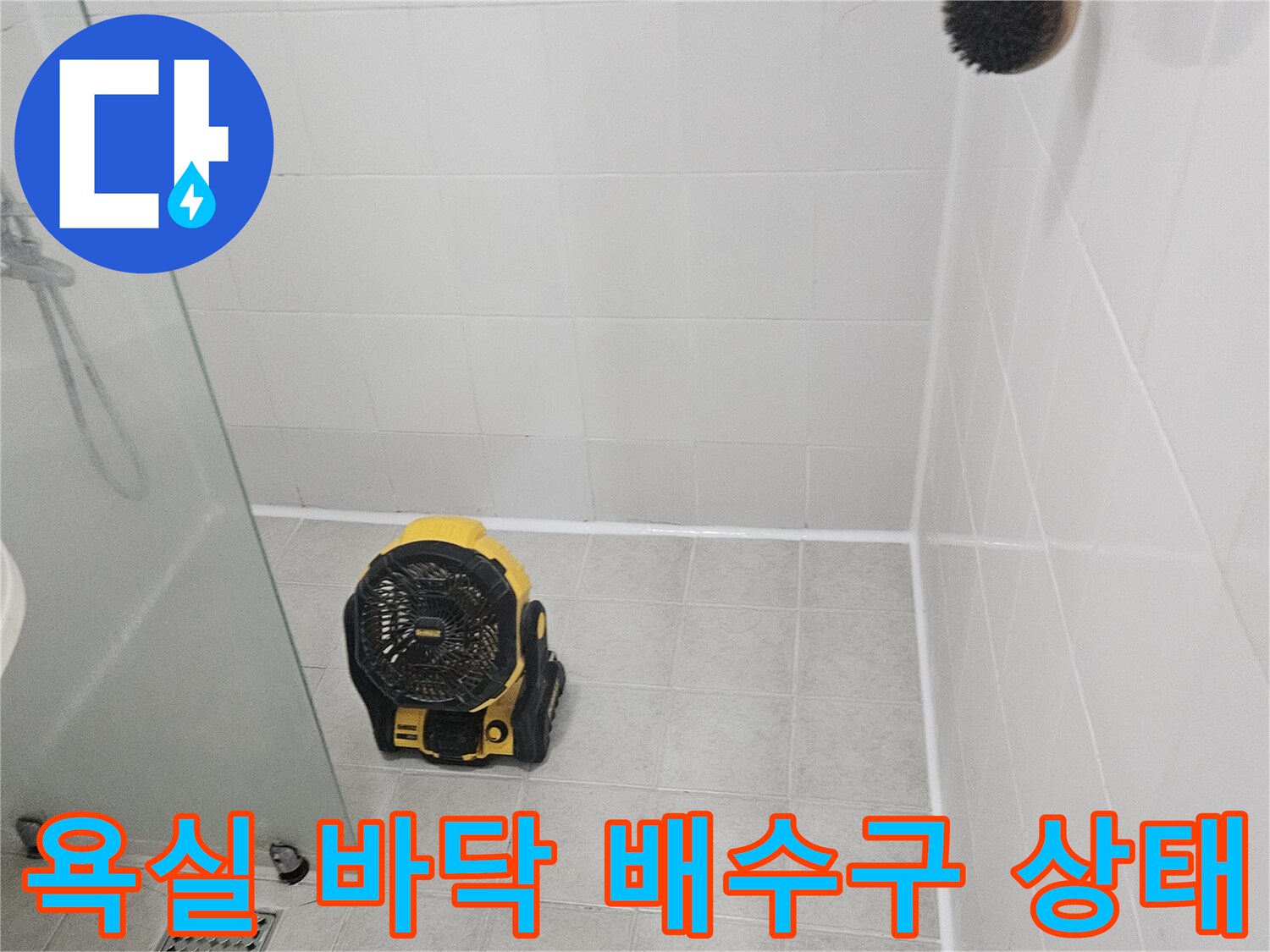 하얀색 타일 바닥에 위치한 배수구와 공구