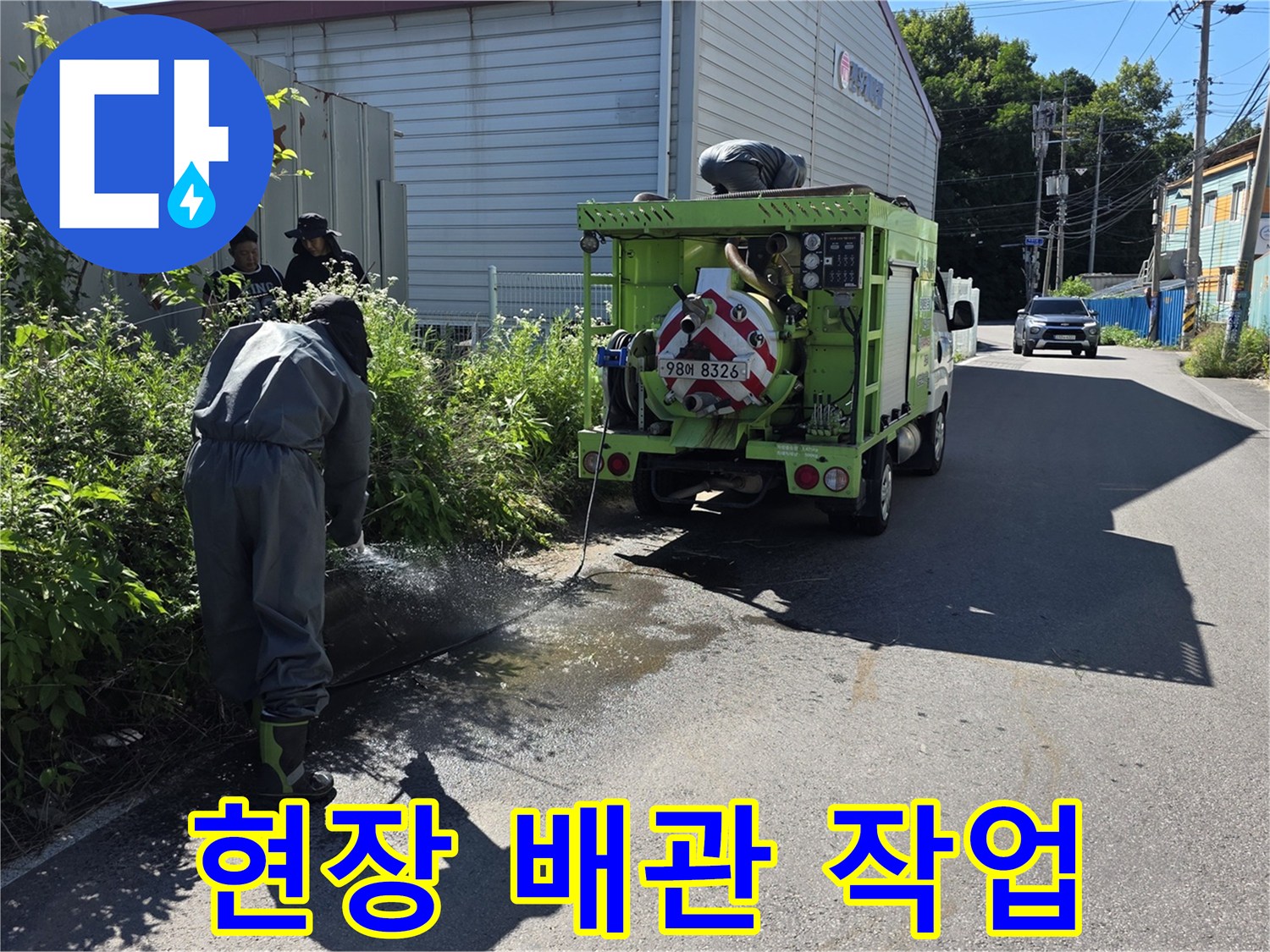 작업자가 맨홀 부근에서 준설 장비를 점검하며 대기하는 모습