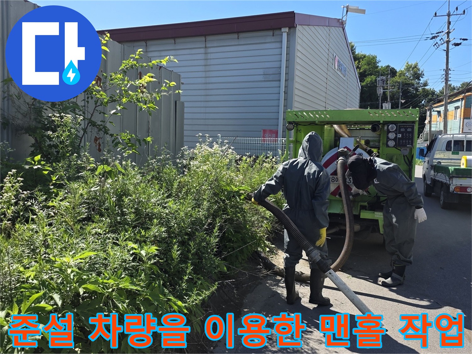 준설 차량의 호스를 활용하여-맨홀 내부의 오물을-흡입하는 공사 현장