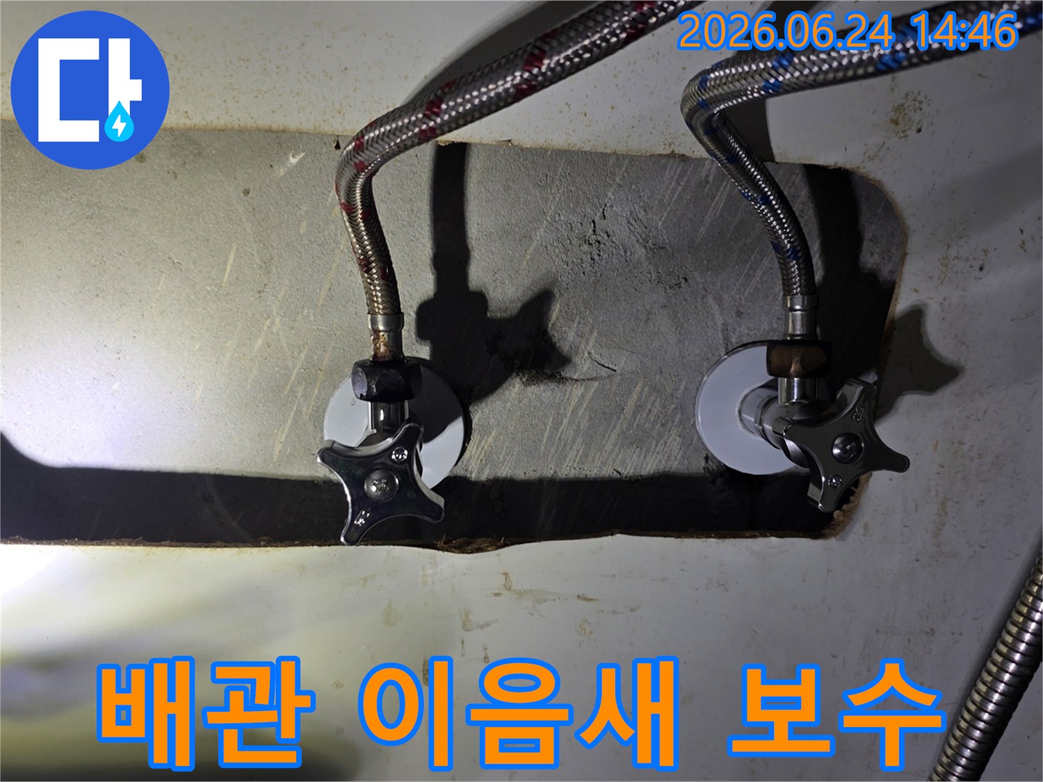 싱크대 하부-수도 배관의-이음새에서-발견된-누수-징후를-전문가가-점검하고-보수-계획을-세우는-사진