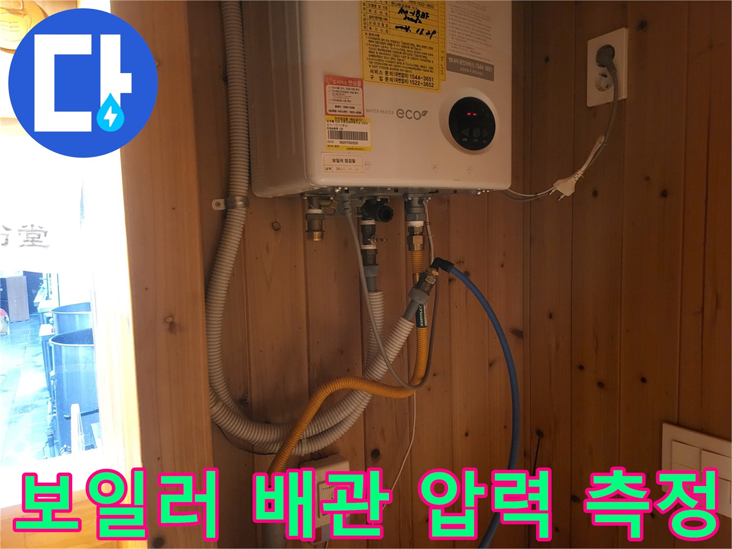 보일러 하단 연결 부위에 설치된 압력계와 호스 사진