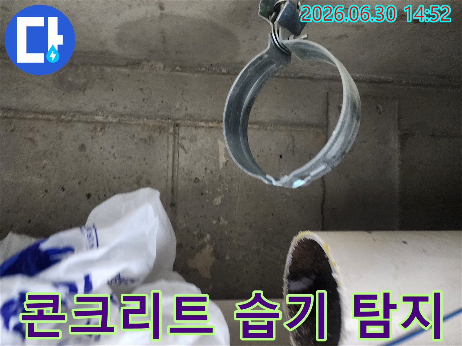 습기가 스며들어-변색된 콘크리트 구조물과-배관 고정 밴드의-누수 현장 상세 이미지