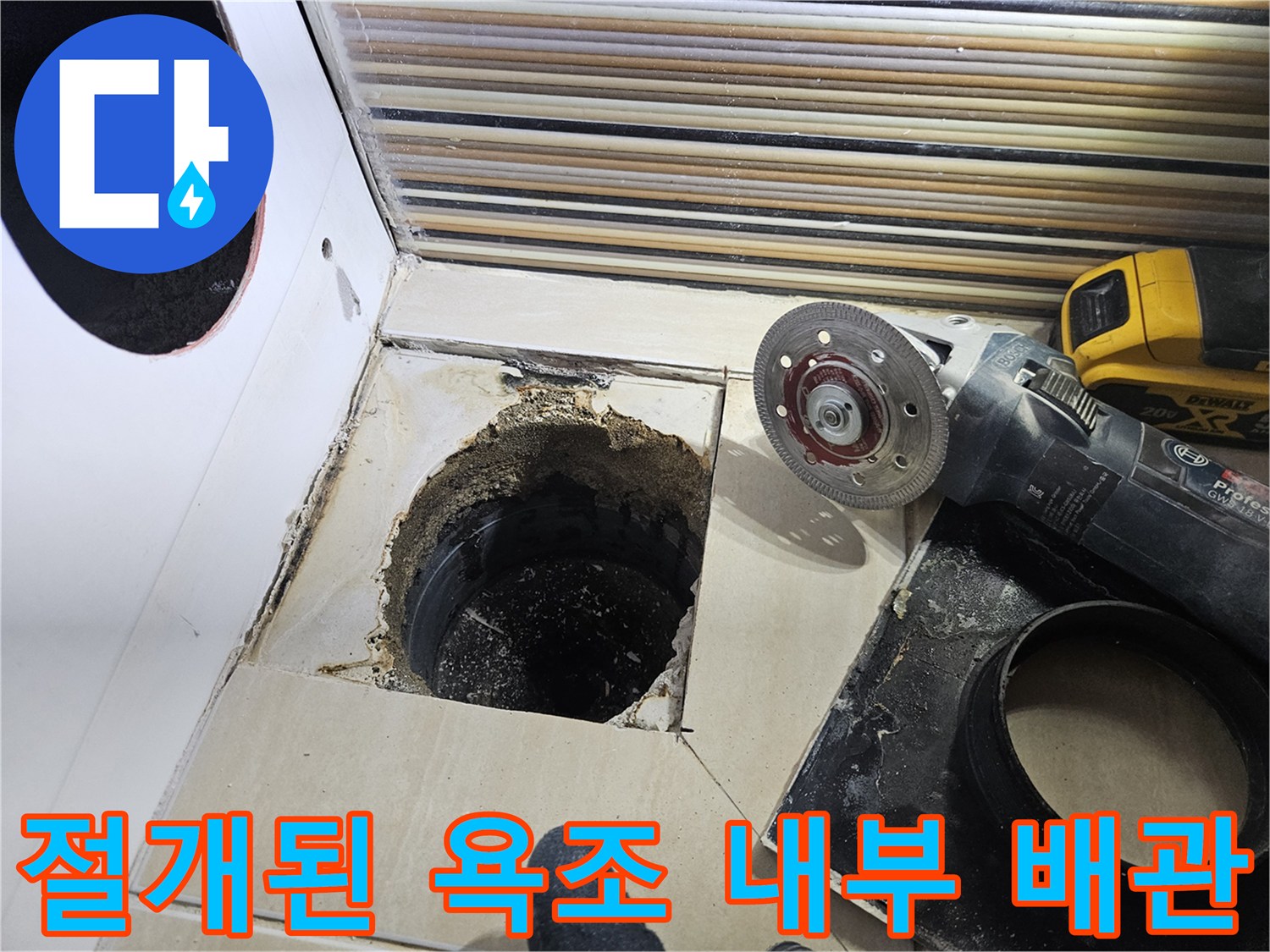타일 절단 작업 후 드러난 검은색 배관 입구와 주변 마감재