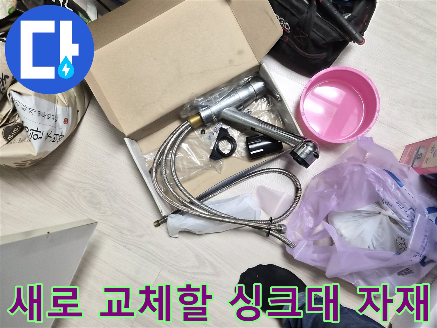 바닥에 놓인 새 싱크 수전과 작업용 공구 상자