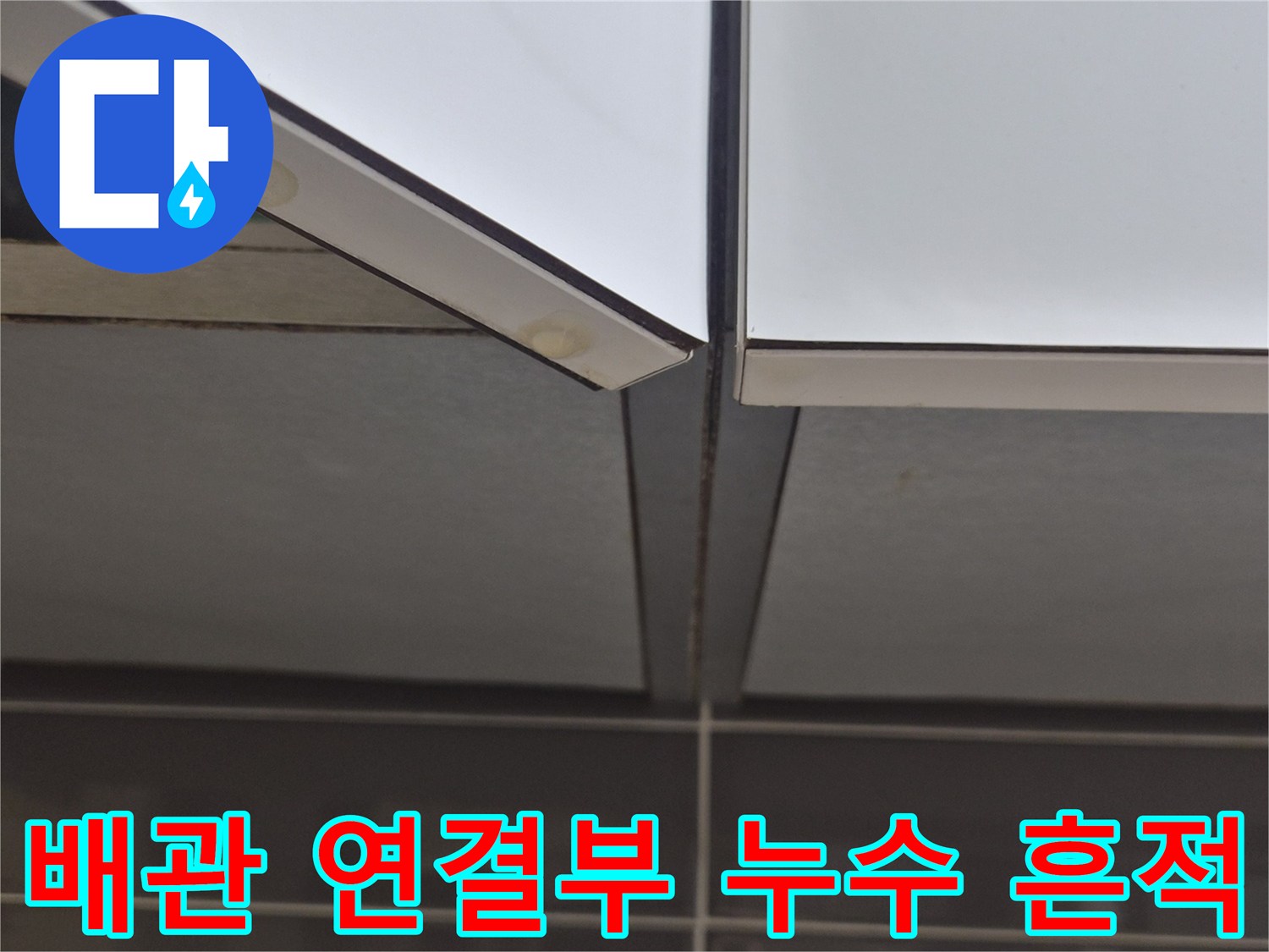 싱크대 하부장 배관 연결 부위의 젖은 흔적과 오염