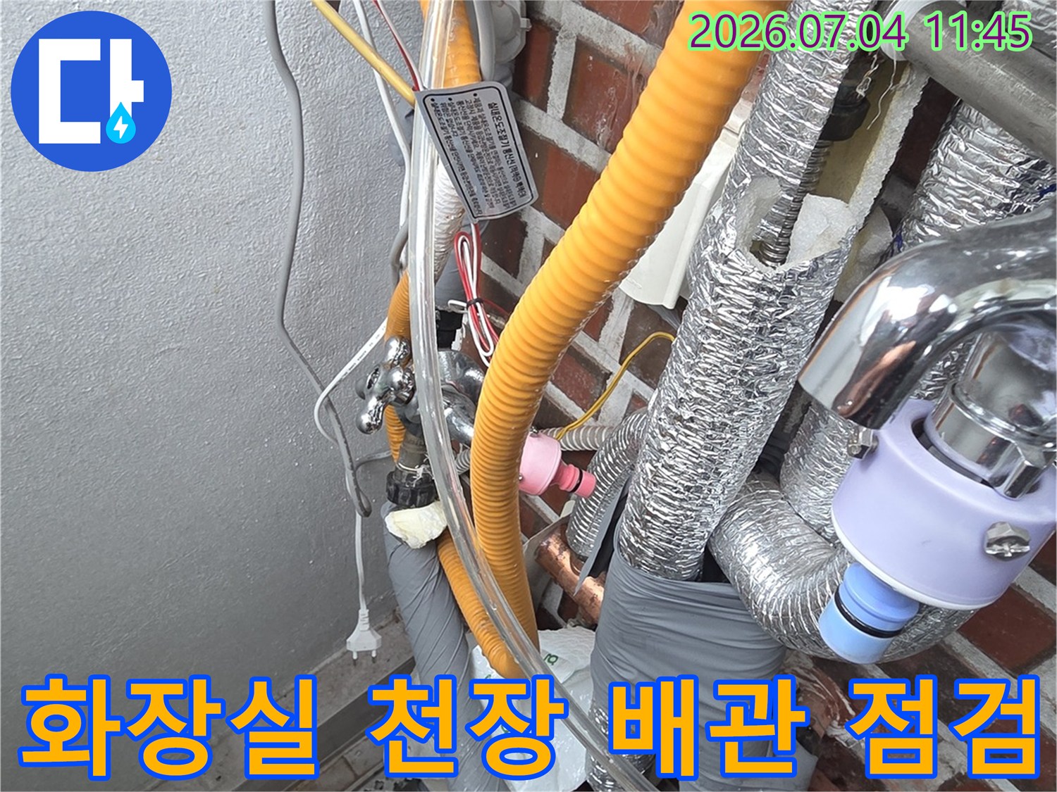 노란색 단열재로 감싸진 화장실 천장 배관과 작업자가 점검하는 모습