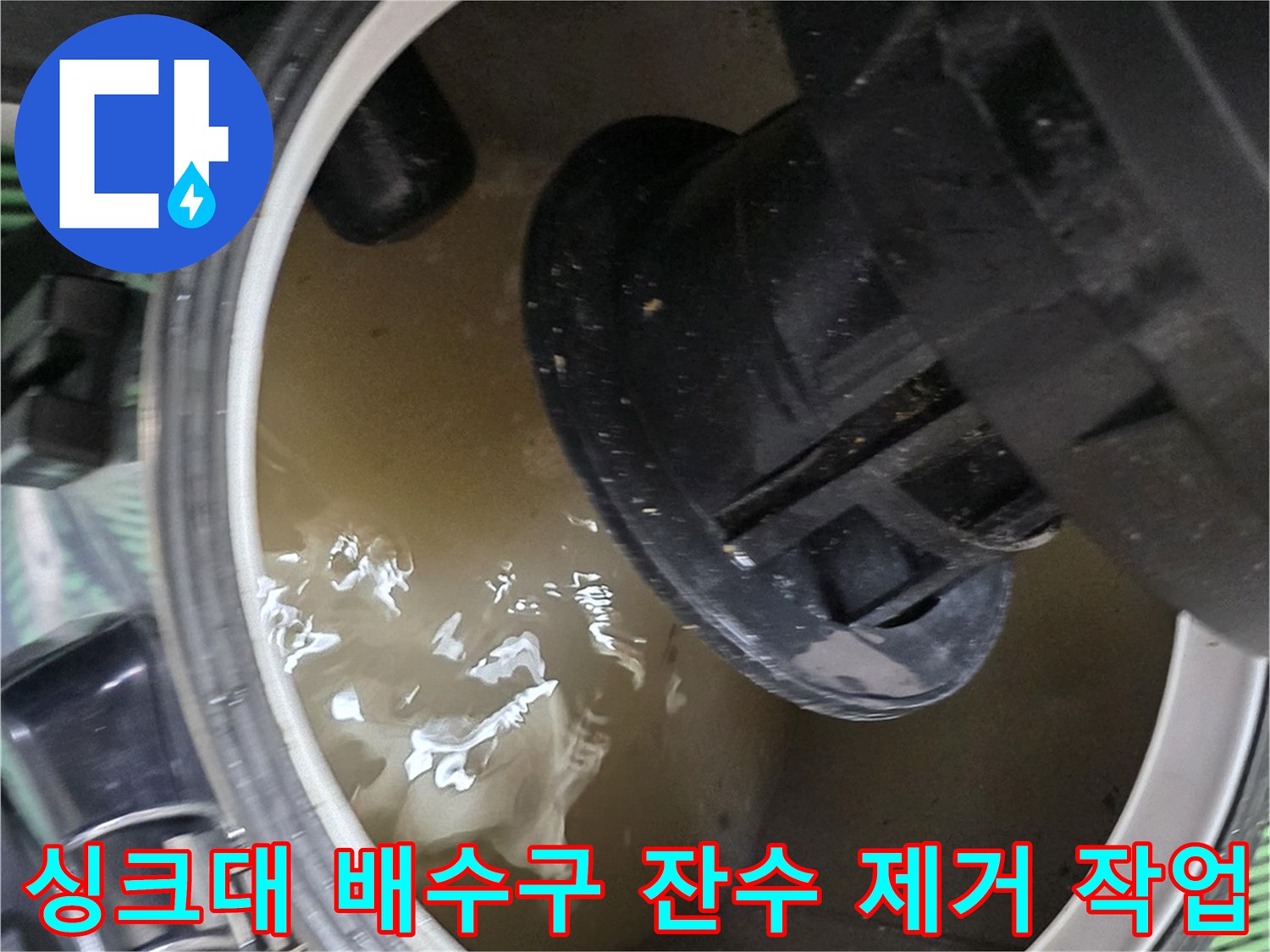 싱크대 하부장 배수구 주변에 고여있는 오염된 물을 집진기로 흡입하는 모습
