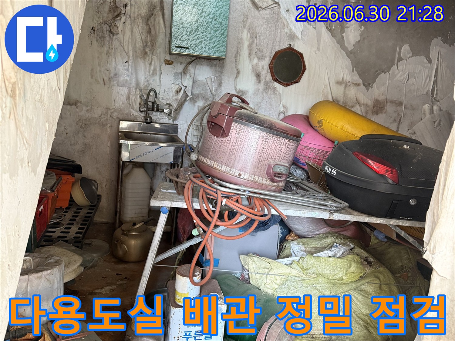 다용도실 내부에 위치한 복잡한 배관과 주변 자재들을 점검하는 모습