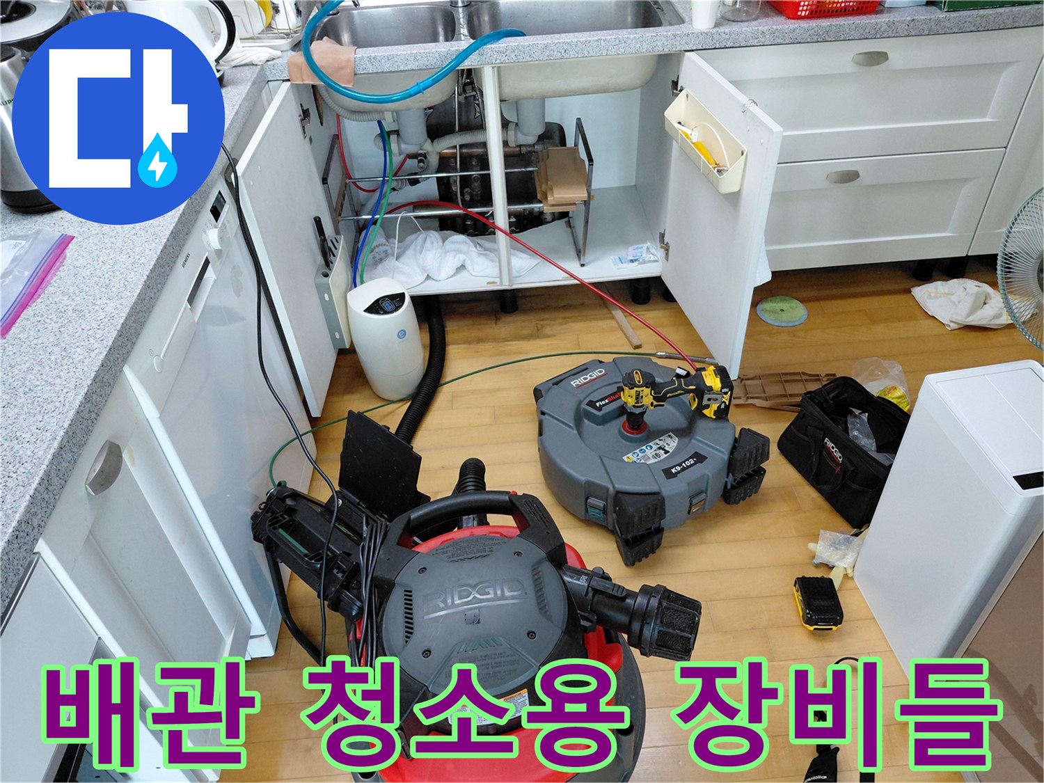 싱크대 아래쪽-작업을 위해 배치된 석션기와 배관 스케일링 도구