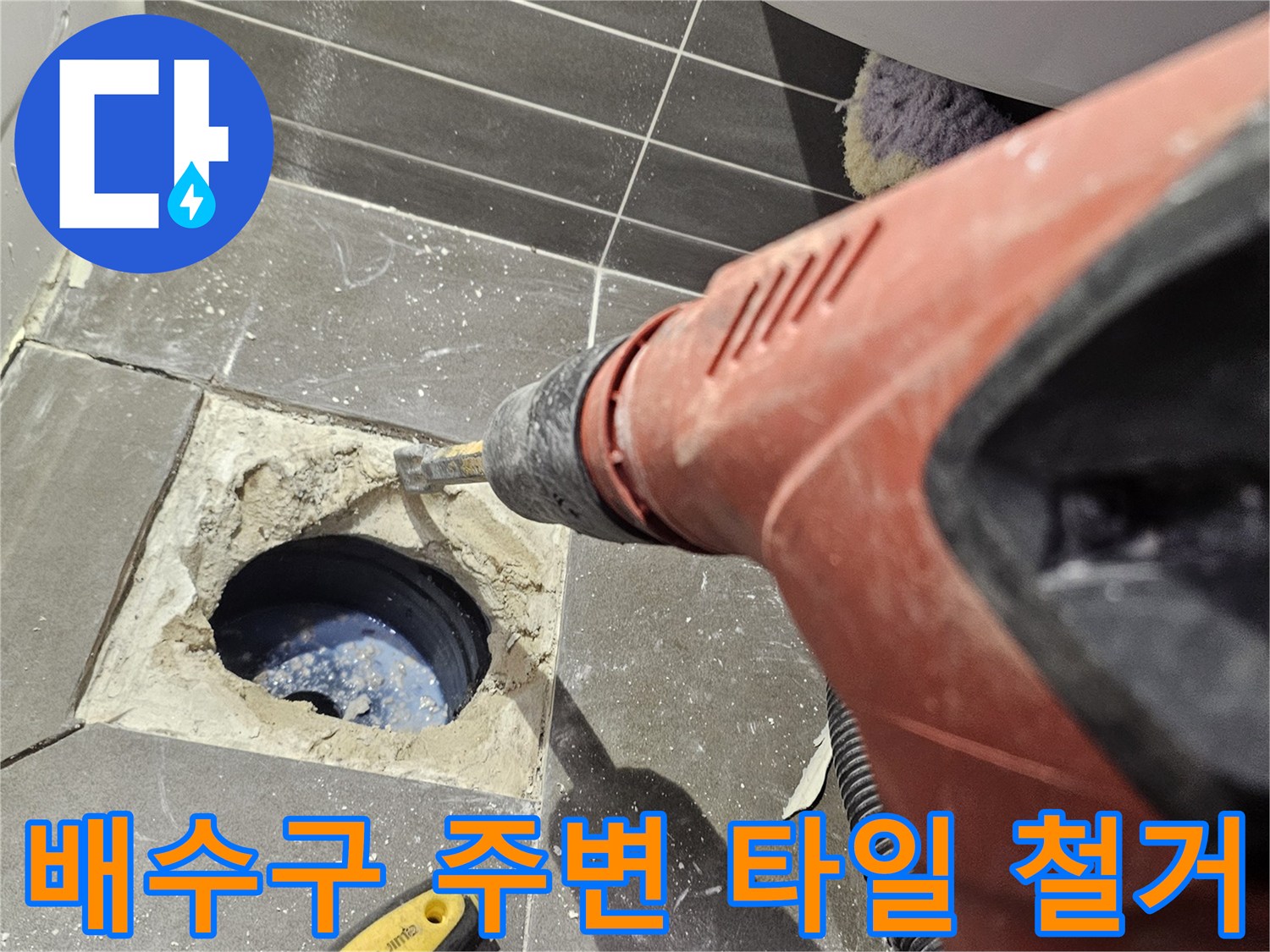 화장실 배수구 주변의 타일을 제거하여 내부 배관 상태를 확인하는 모습입니다.