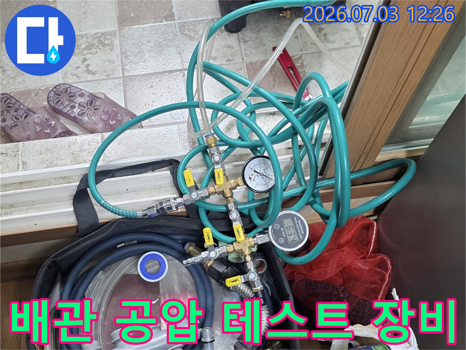 누수 탐지를 위해 연결된 다양한 색상의 호스와 압력계 장비