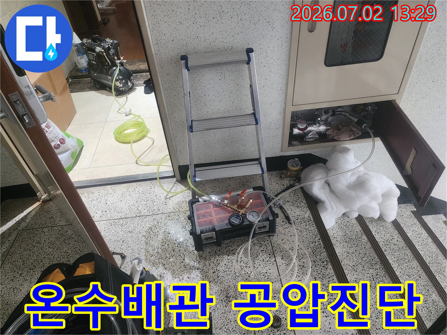 울산 중구 우정동에서 온수배관 누수 문제를 해결하기 위해-공압검사 장비를 설치하고 압력 변화를 측정하여-누수 지점을 정확히 파악하는 전문 작업 현장입니다.