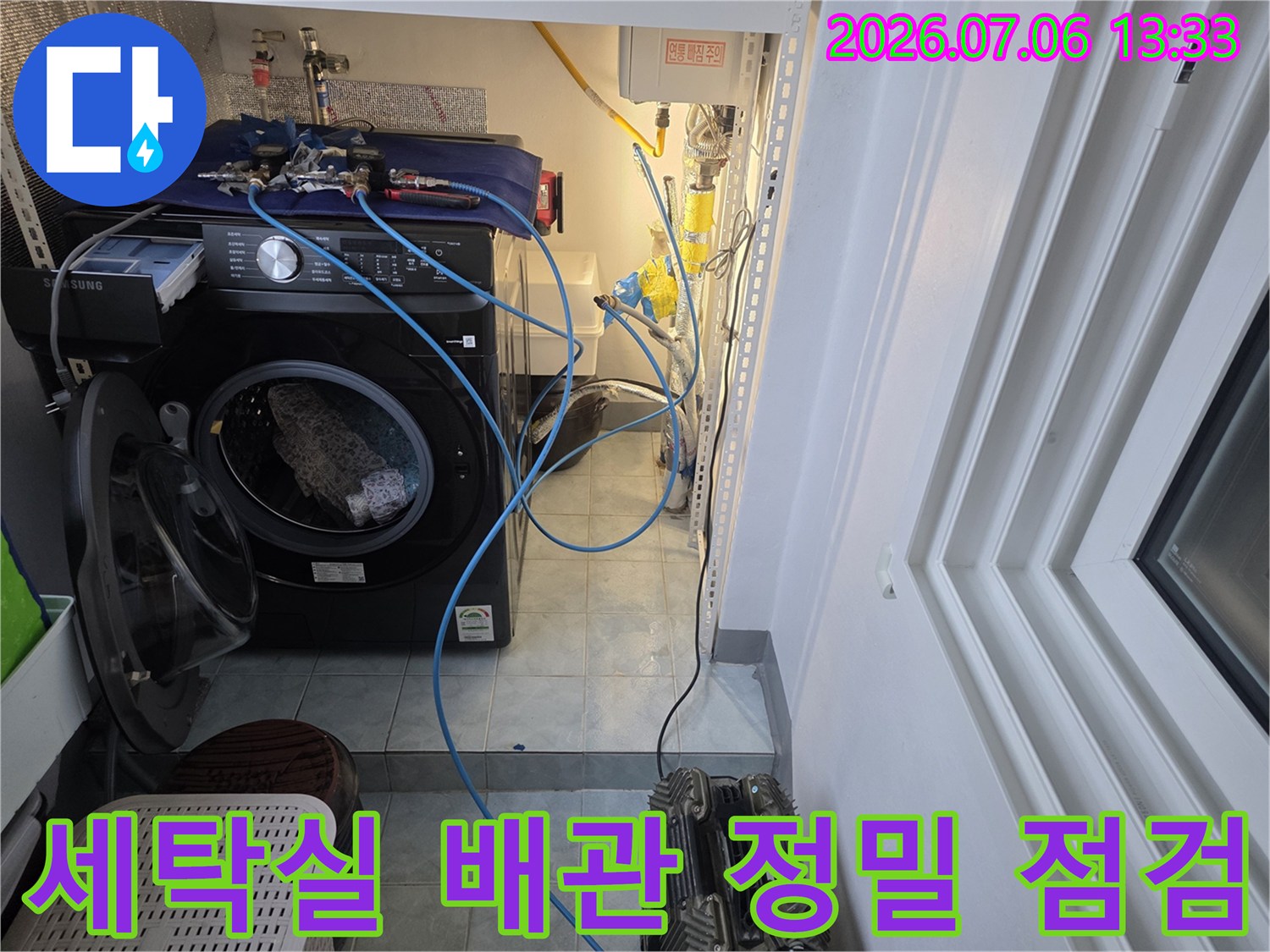 세탁실 내부의 복잡한 수도 배관과 세탁기 설치 공간을 점검하는 모습