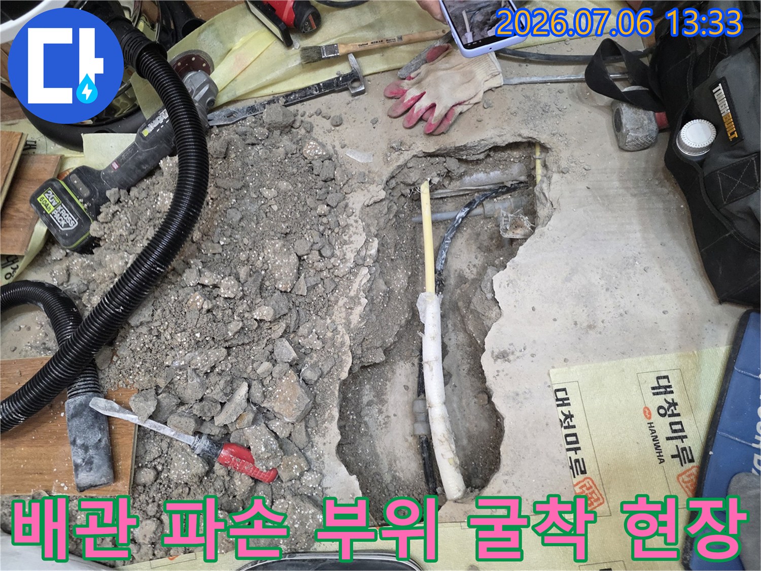 파헤친 콘크리트 바닥 속 노출된 배관과 청음식 탐지기 장비