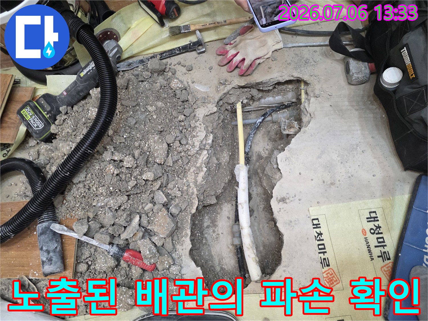 흙과 돌이 섞인 지면을 파고 드러난 배관의 상태를 점검하는 현장