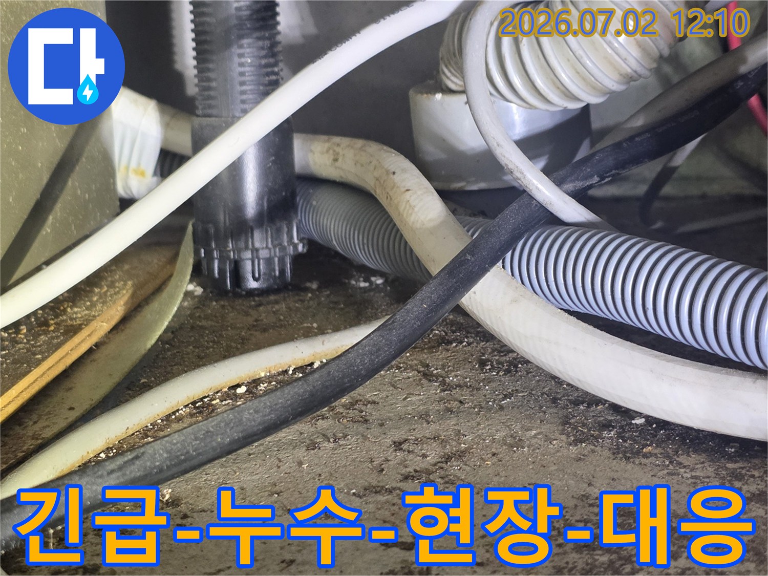 이 사진은-긴급한 누수 상황에서-복잡한 배관과-전선 사이를-점검하는-모습을 보여줍니다.